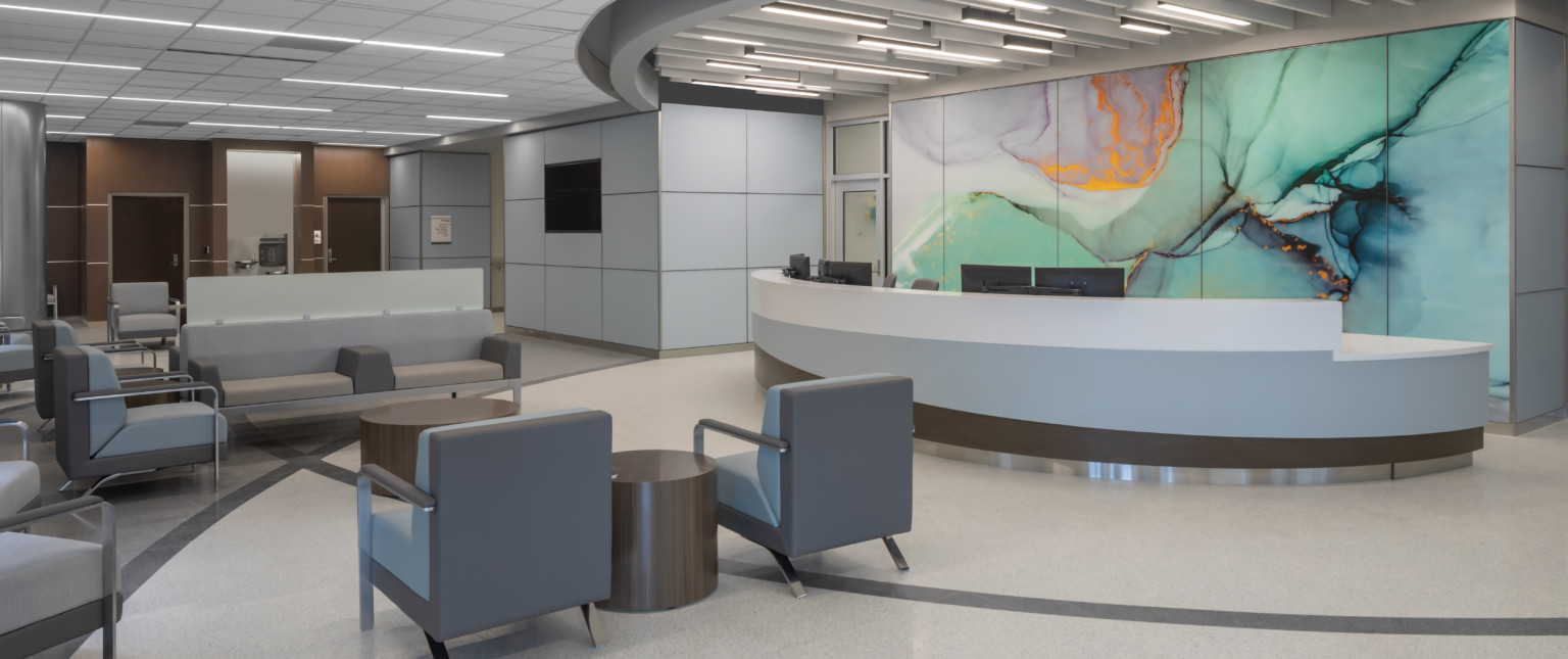 Waiting area lobby with long rounded reception desk in front of marbled wall mural in green with gold and purple accents