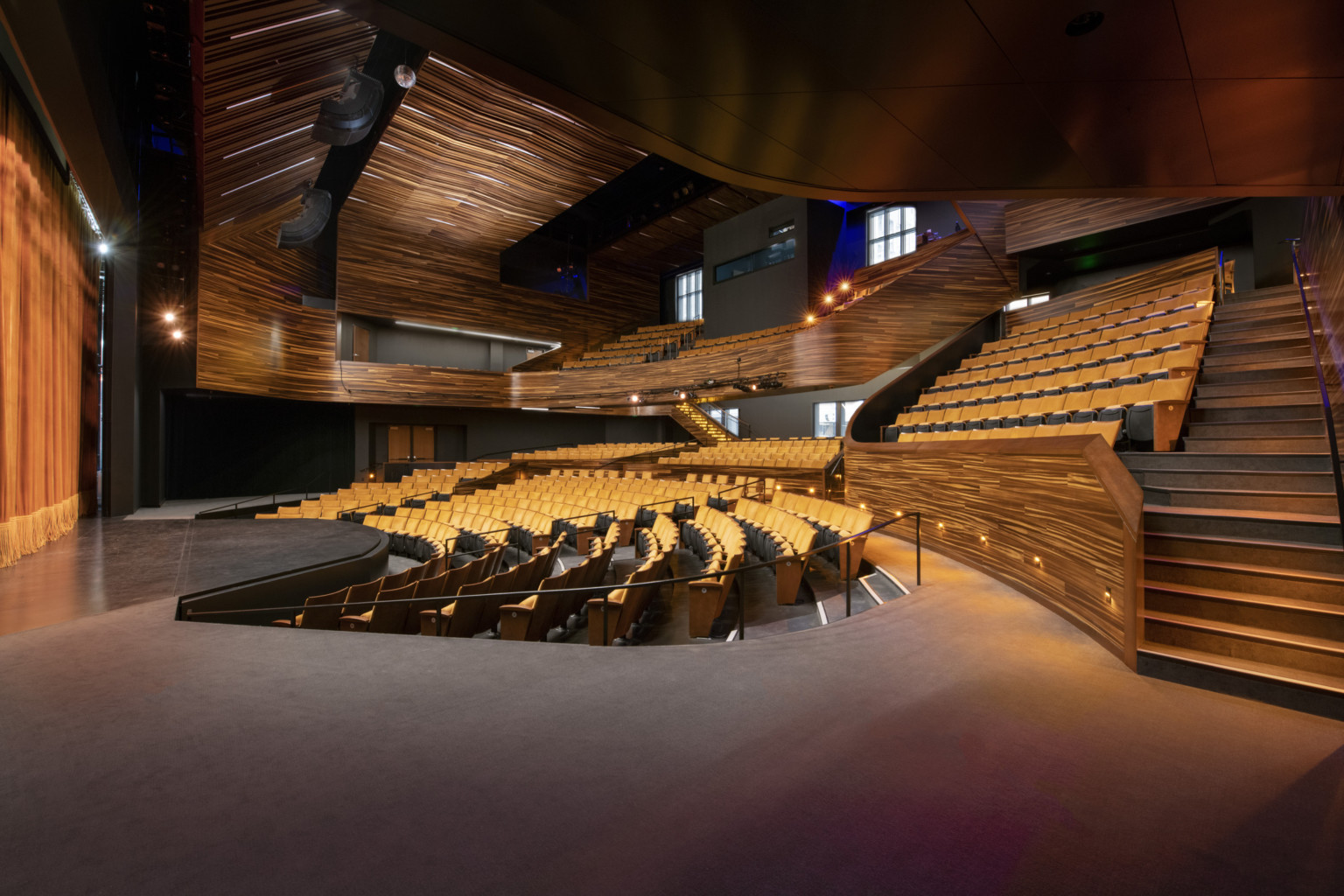 theater with wooden finishes and yellow seating, stairs on the right to balcony at Point Park University Pittsburgh Playhouse