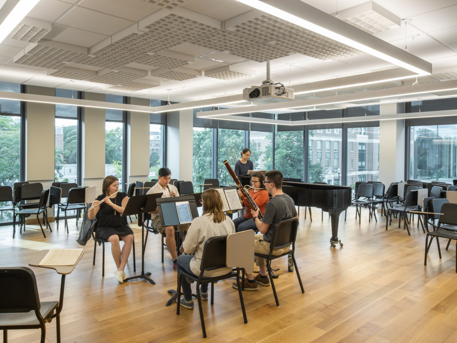 Students practicing in corner upper-level room with floor to ceiling windows and geometric lighting
