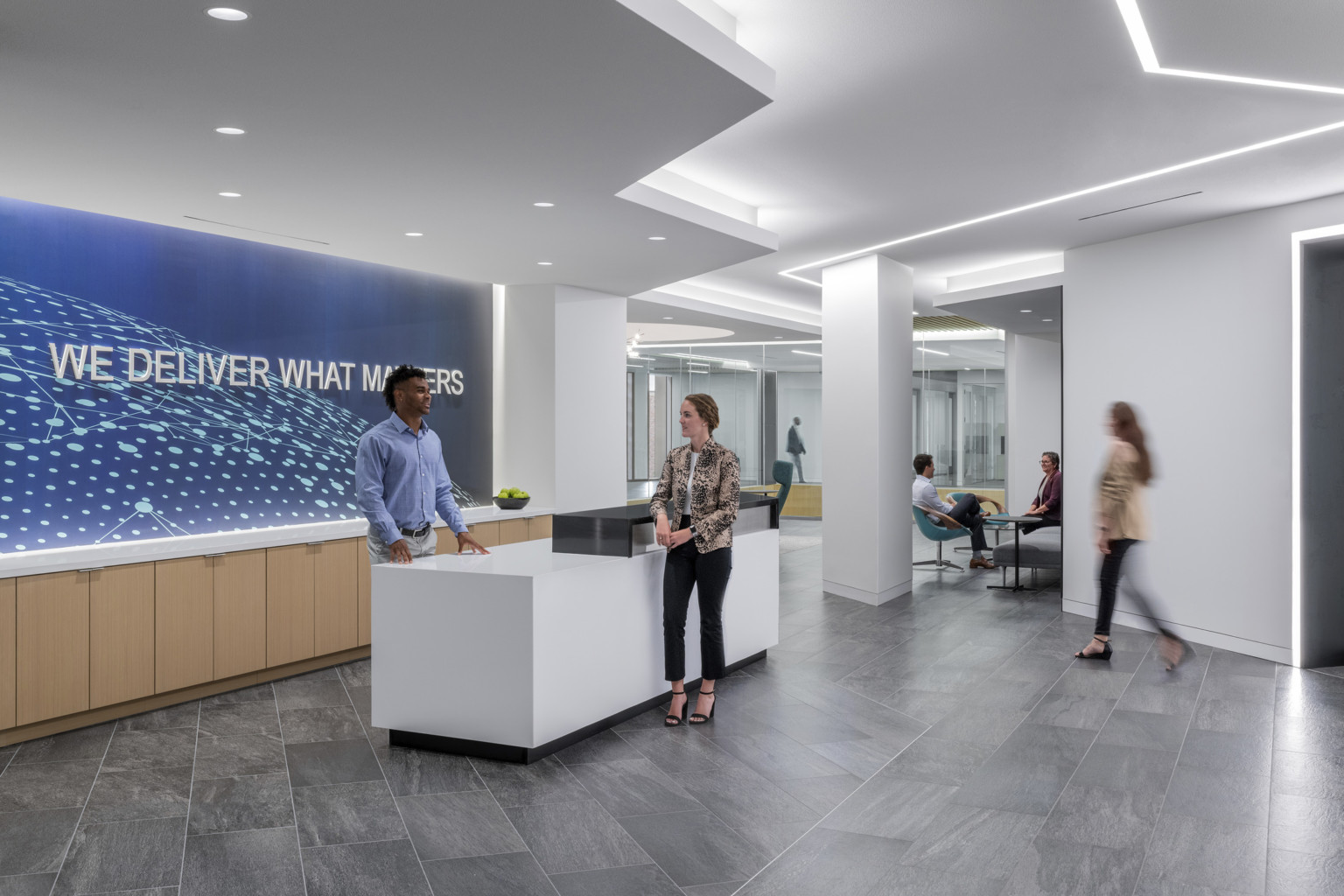 BNSF Logistics lobby with mural and counter behind reception desk with "We deliver what matters" written on wall