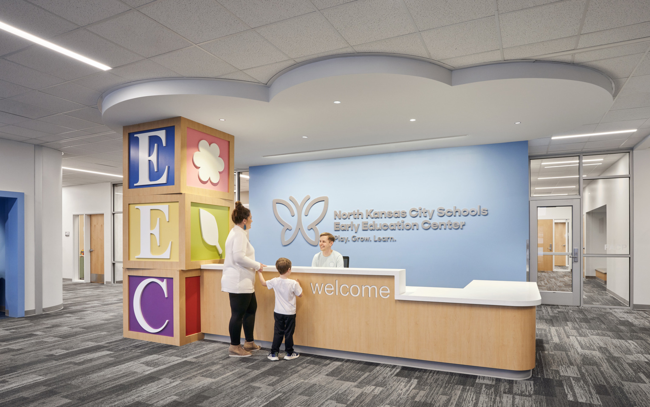 welcome desk in front of a blue wall and cloud formation on ceiling at the North Kansas City Early Education Center