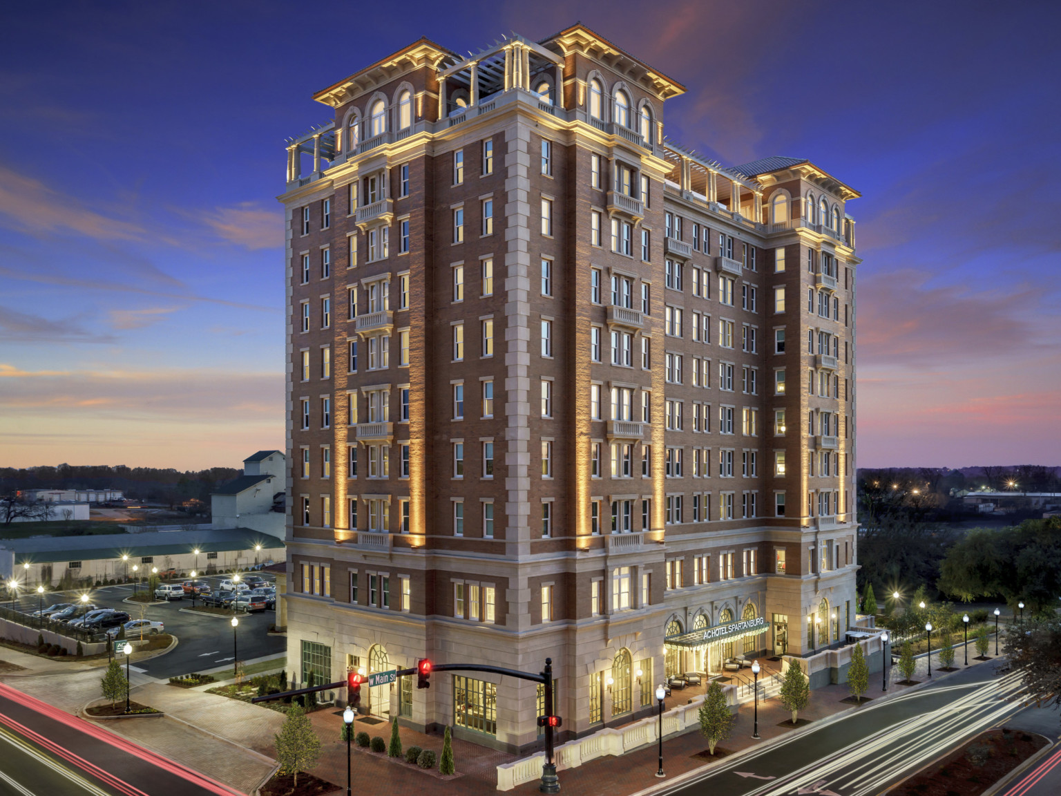 Exterior of building from aerial corner view. Main entry is to the right, with a parking lot behind the 10 story building