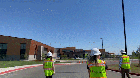 young professionals walking to a site visit with hard hats and vest, commitment plays on screen young professionals walking to a site visit with hard hats and vest, commitment plays on screen
