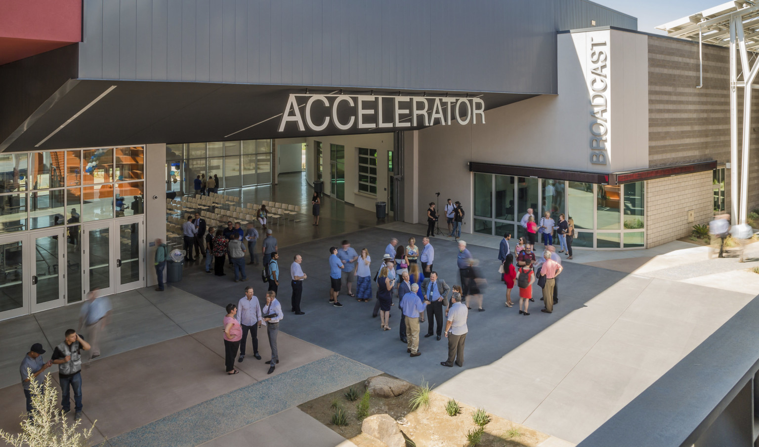 Section of building labeled Accelerator has an angled black roof above wall opening up a seating area to the patio