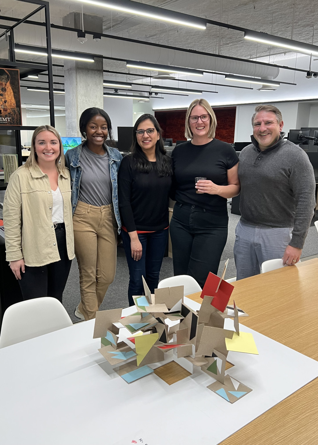 the design team standing together behind their winning 3D collage project