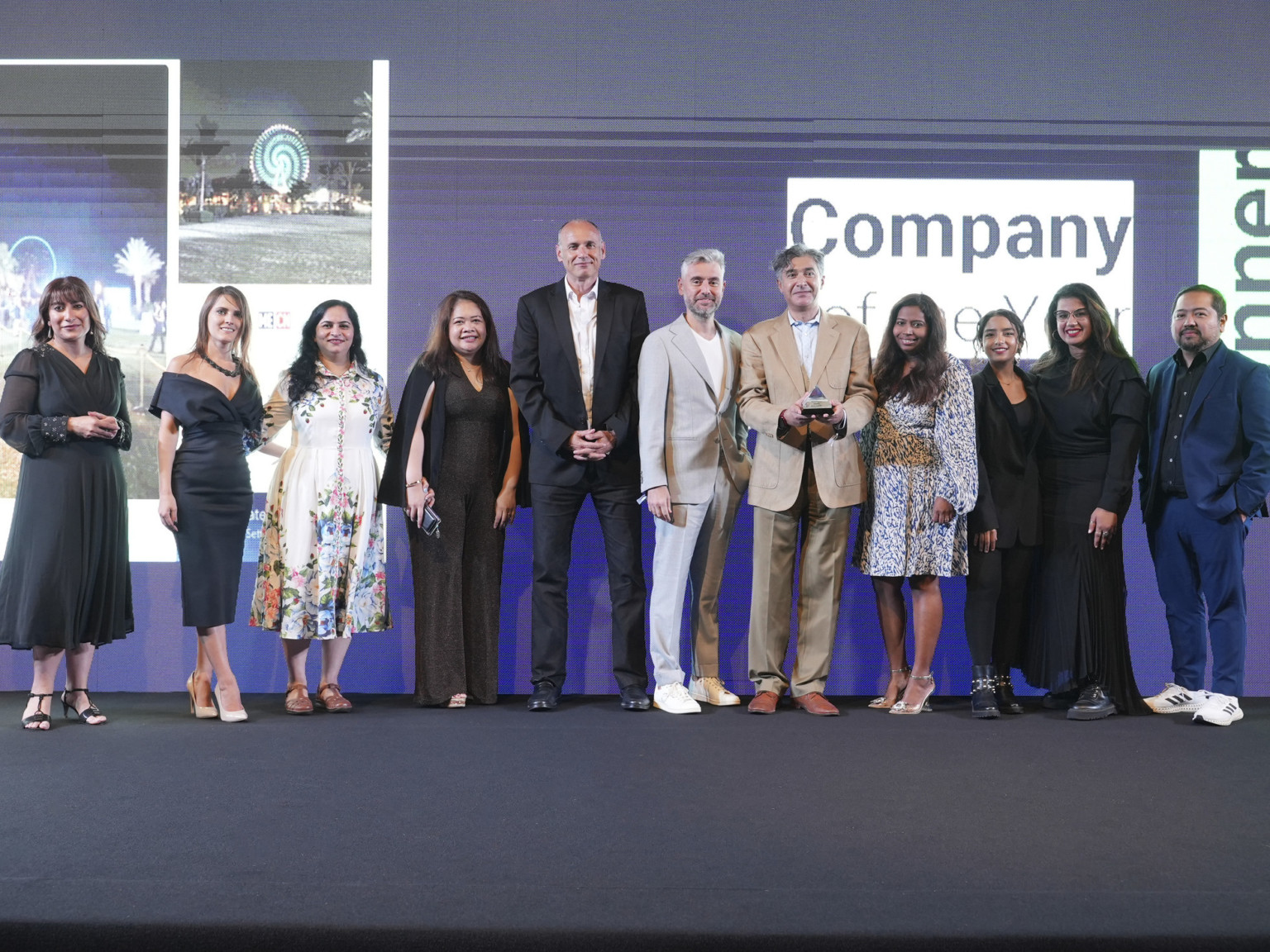 DLR Group's design team in Dubai standing next to each other after receiving the award for 2022 Company of the Year