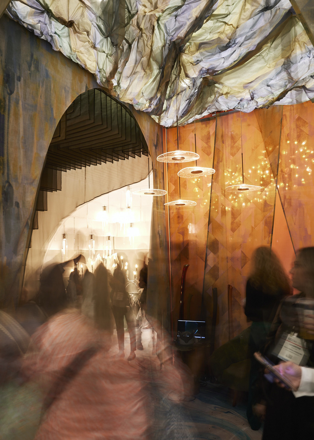 Hallway room within the BDNY booth with marble curtain walls and ceiling illuminated from the opposite side and pendant lights