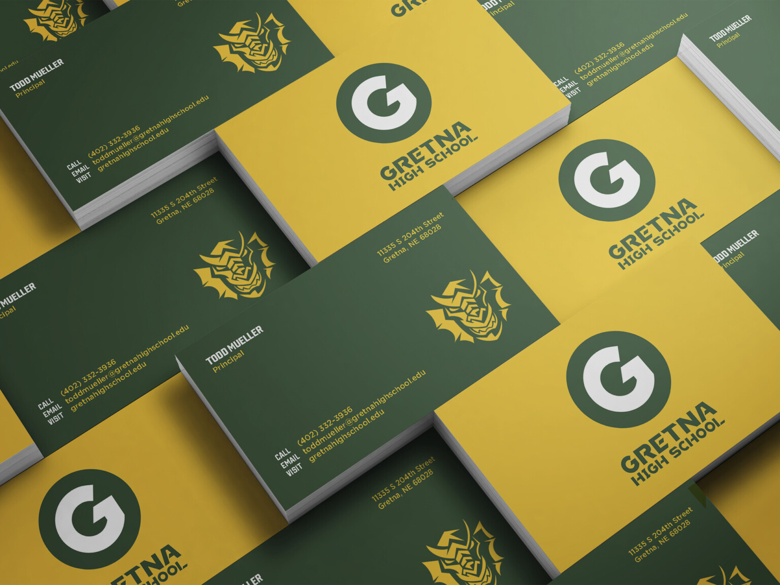 Green and yellow business cards with Gretna High School logo on yellow side