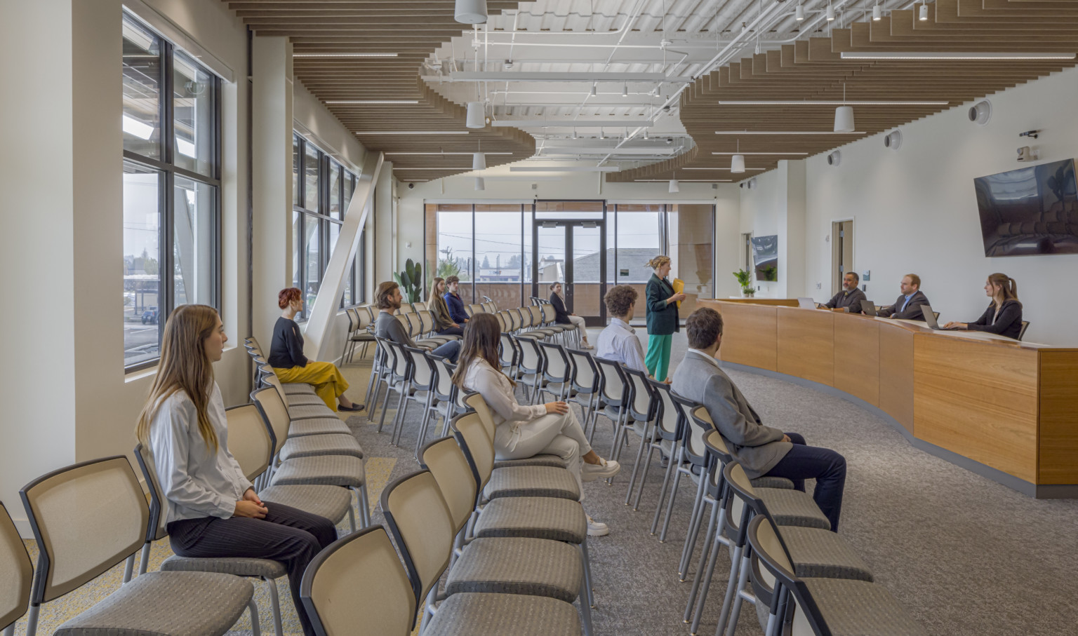 Interior room in Marysville Civic Center with rows of seat facing wood desks, large windows behind