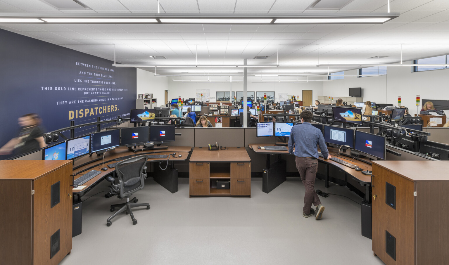 Interior of the Will County Public Safety Complex. Dark brown desks, blue wall