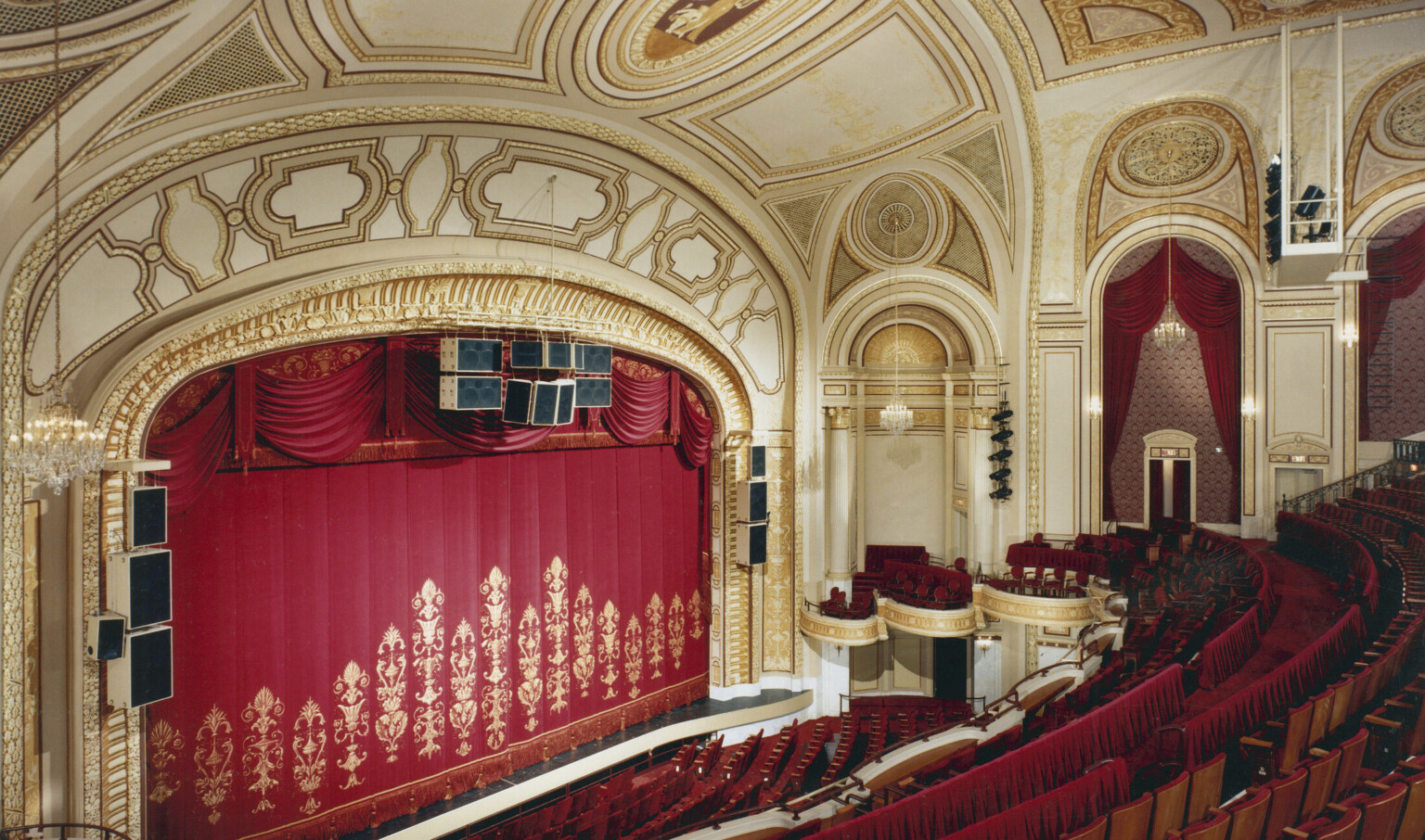 Interior of Playhouse Square's Palace Theatre in Cleveland's renovated theater district with gold leaf ceiling ornamentation, red velvet curtains and matching red seating