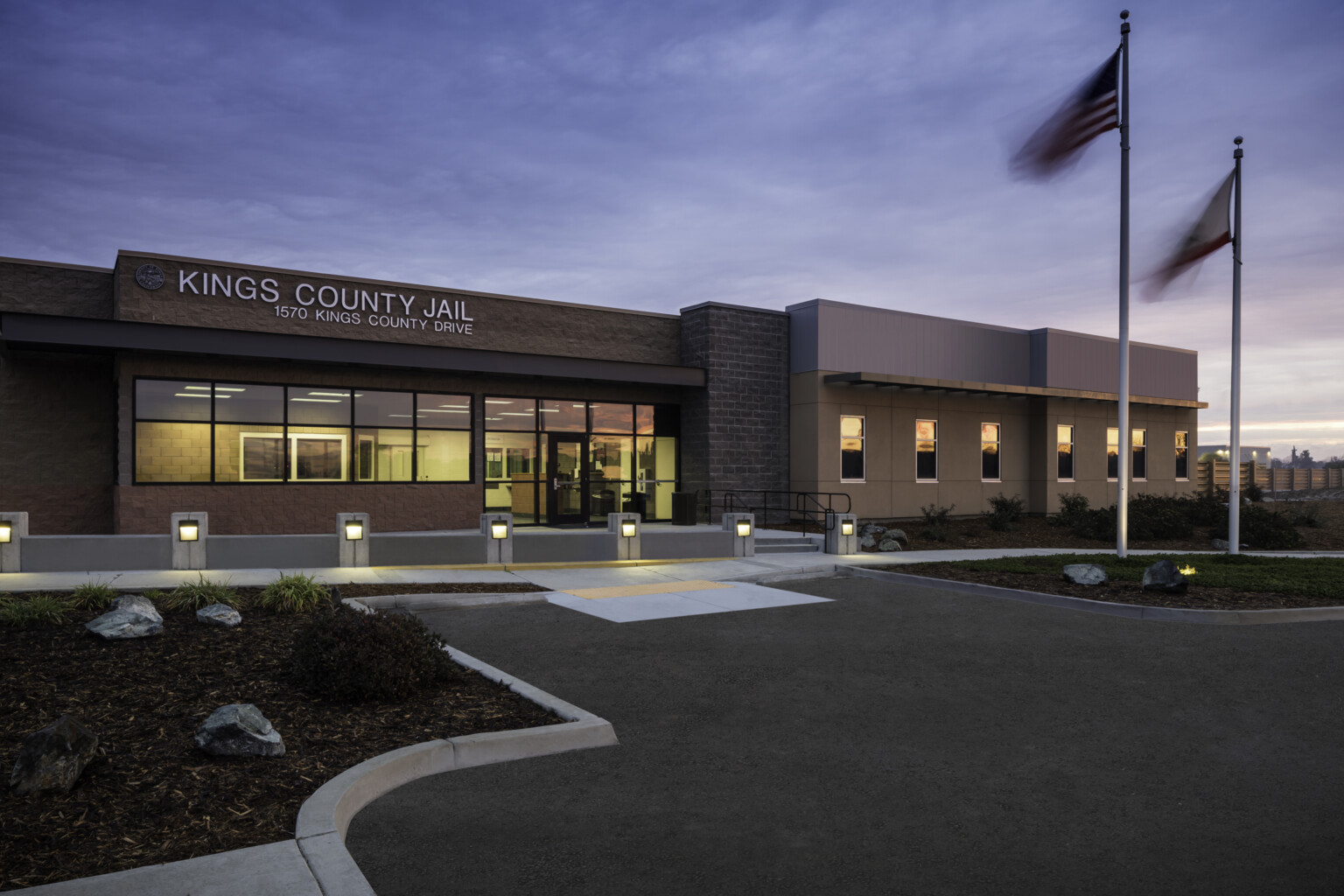 A picture of Kings County Jail at dusk with flagpoles