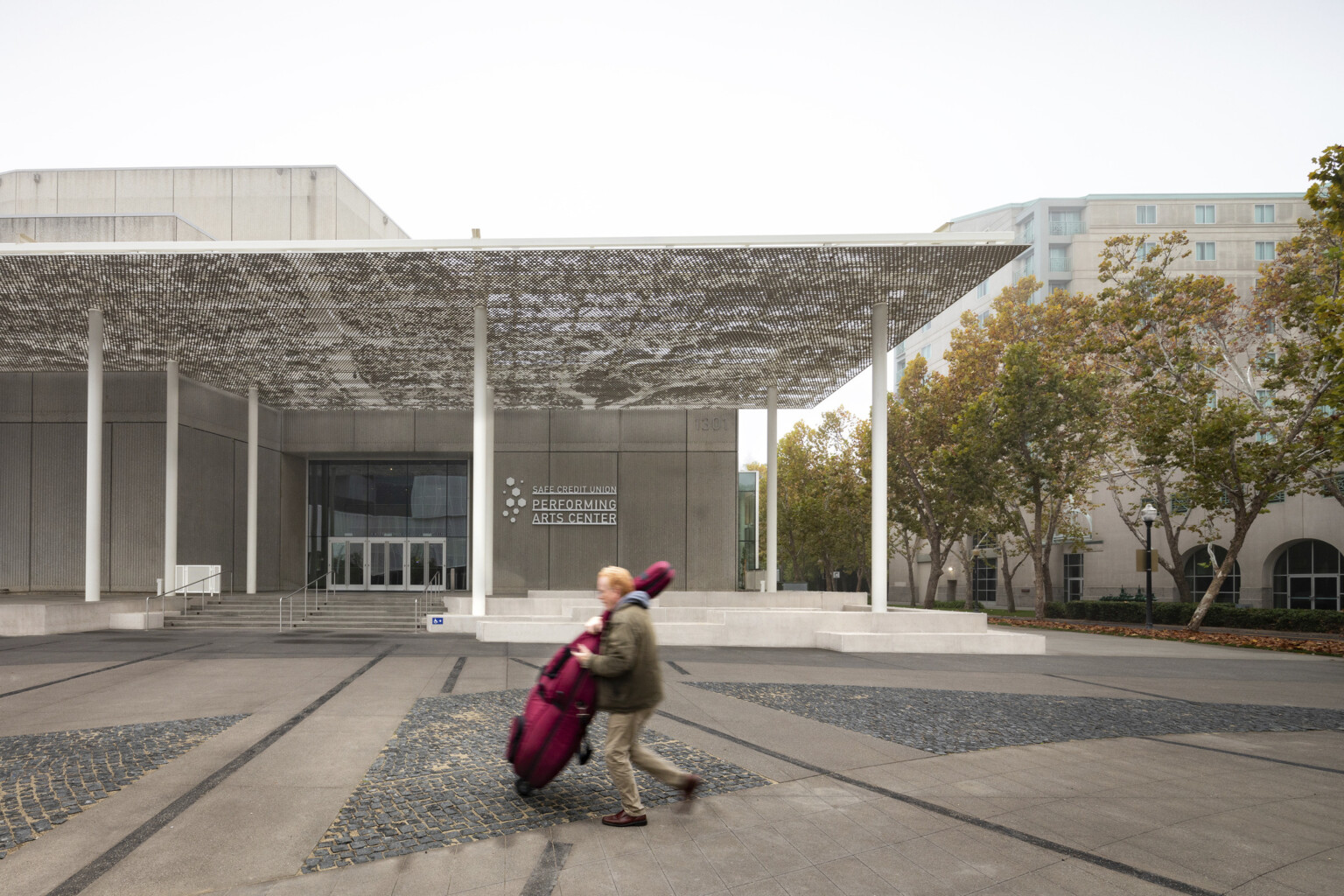 SAFE Credit Union Performing Arts Center exterior with man carrying a cello case