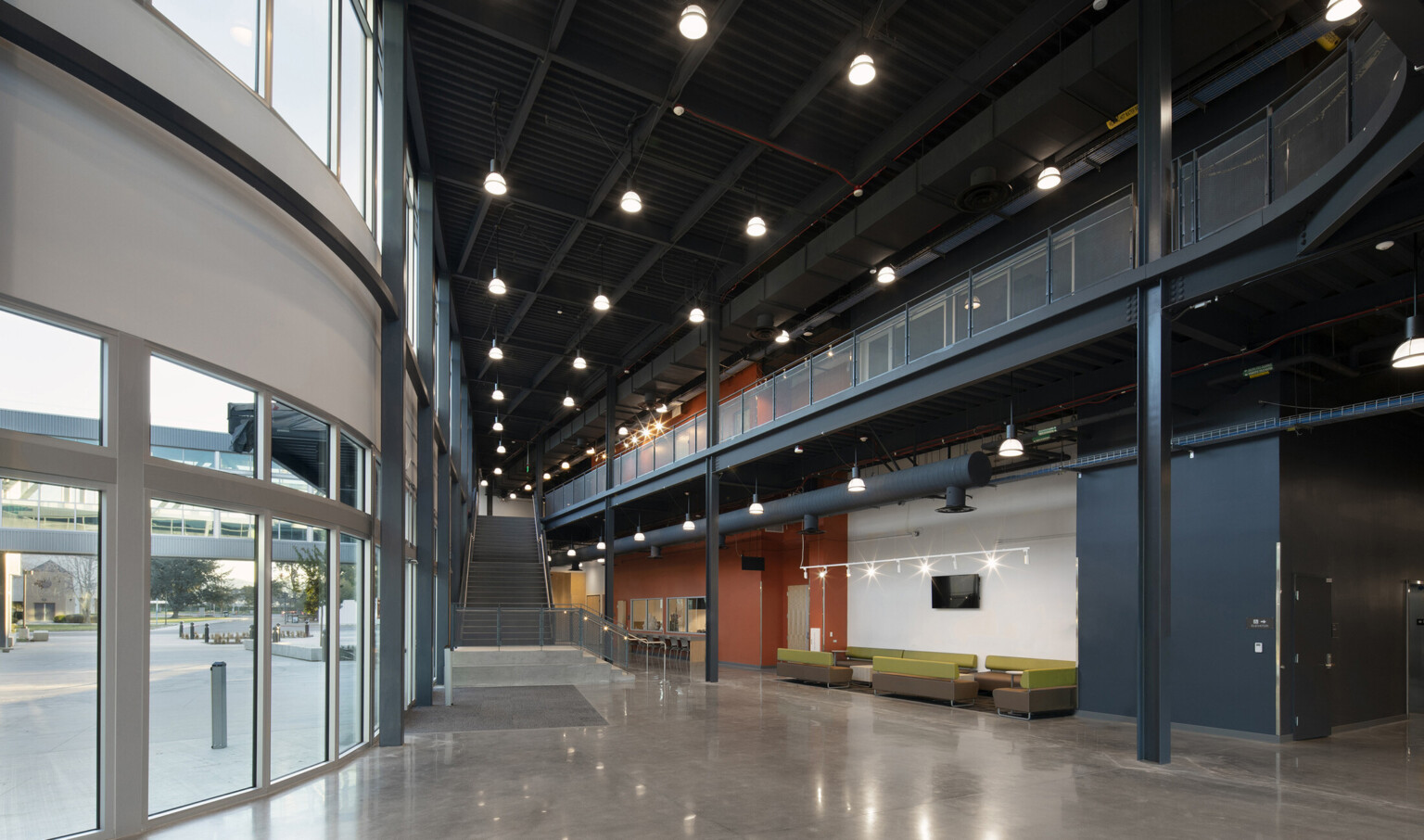 Interior of Fine Arts complex ground-floor, high ceilings, floor-to-ceiling windows, polished concrete flooring, open-floor concept promotes collaboration