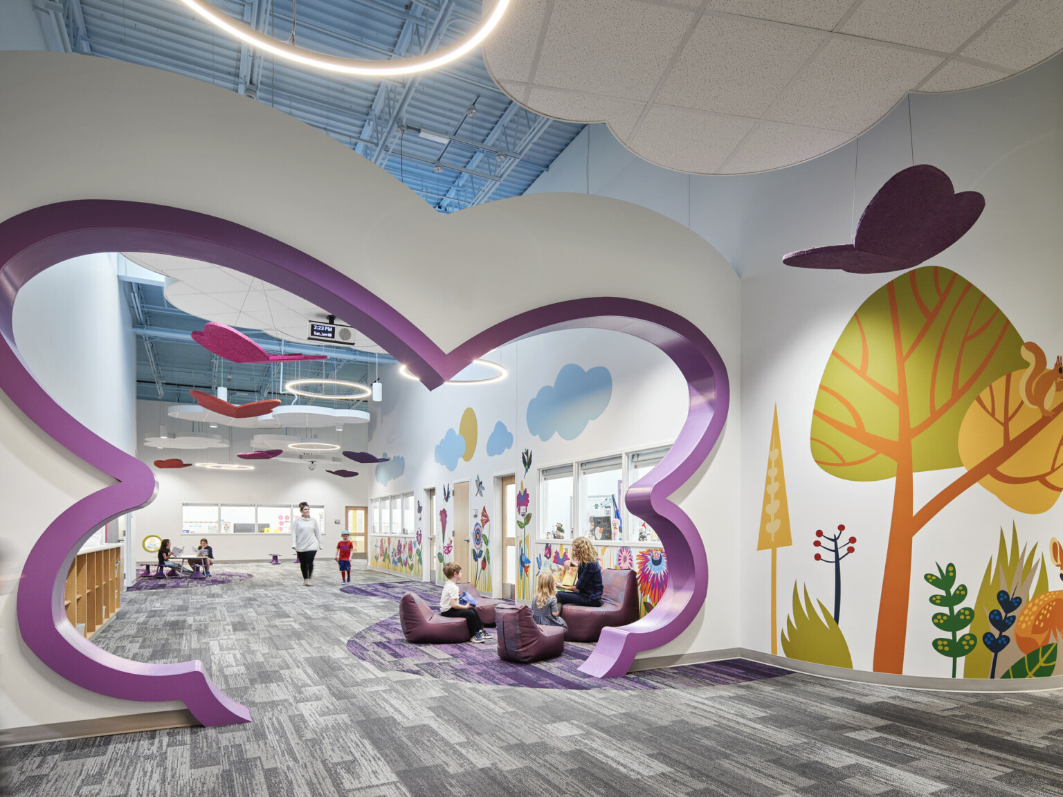 North Kansas City Early Education Center interior hallway with bright mural of trees and abstract-shaped cutout in purple in hall