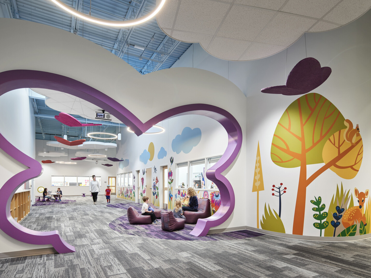 North Kansas City Early Education Center interior hallway with bright mural of trees and abstract shaped cutout in hall