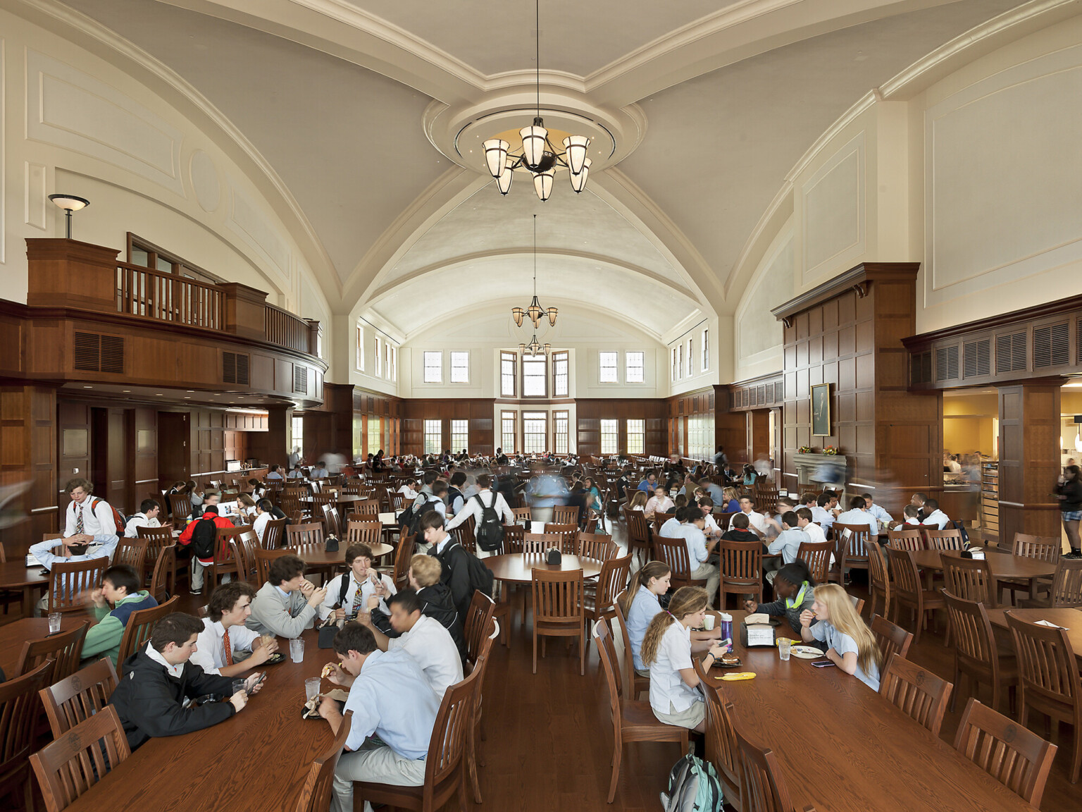 students dine in a 650-seat grand dining hall, vaulted wood beams over traditional cherry wood tables and chairs