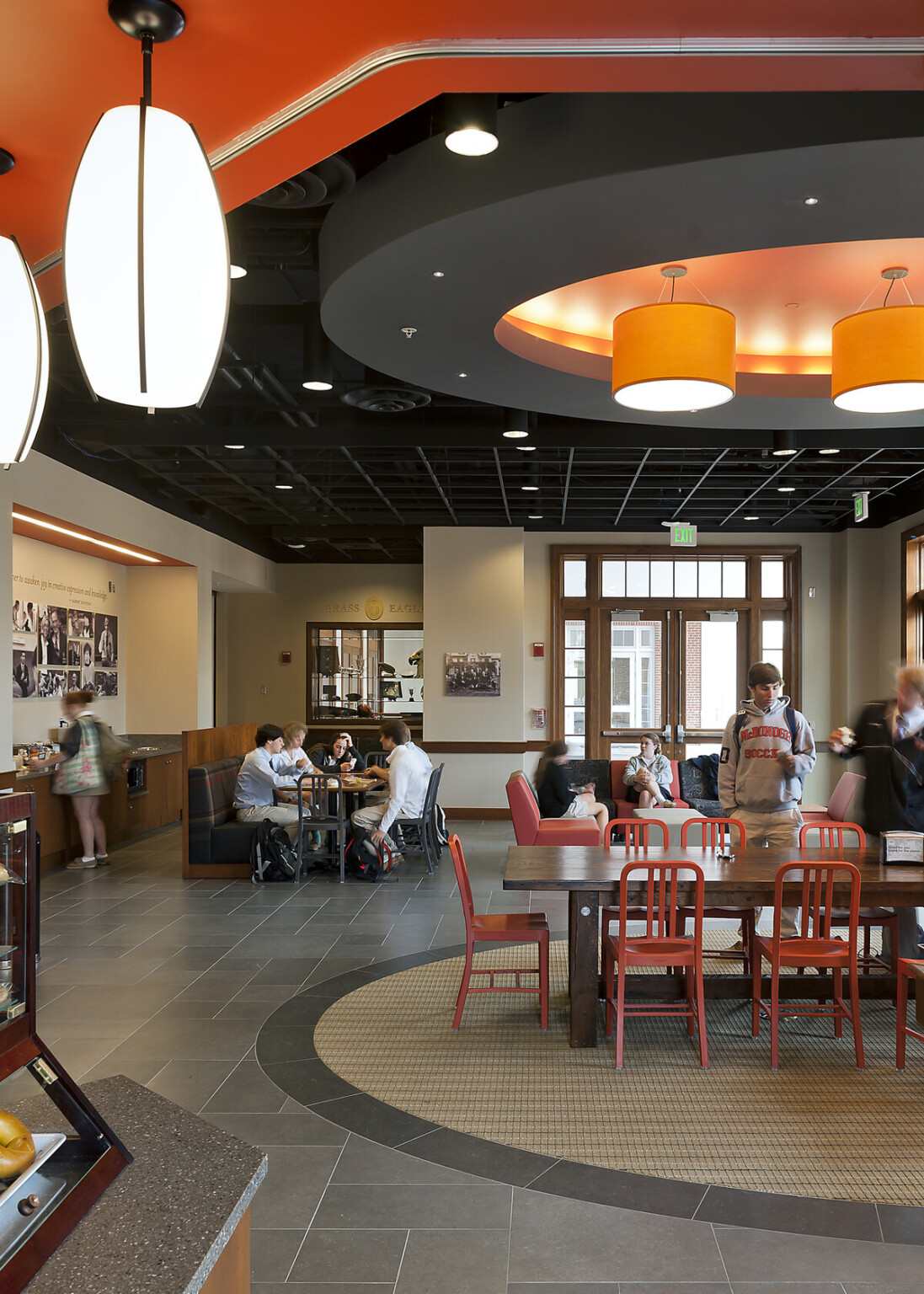 seating area for the casual dining room, custom pendant lights hang from high-ceiling, stone tile flooring