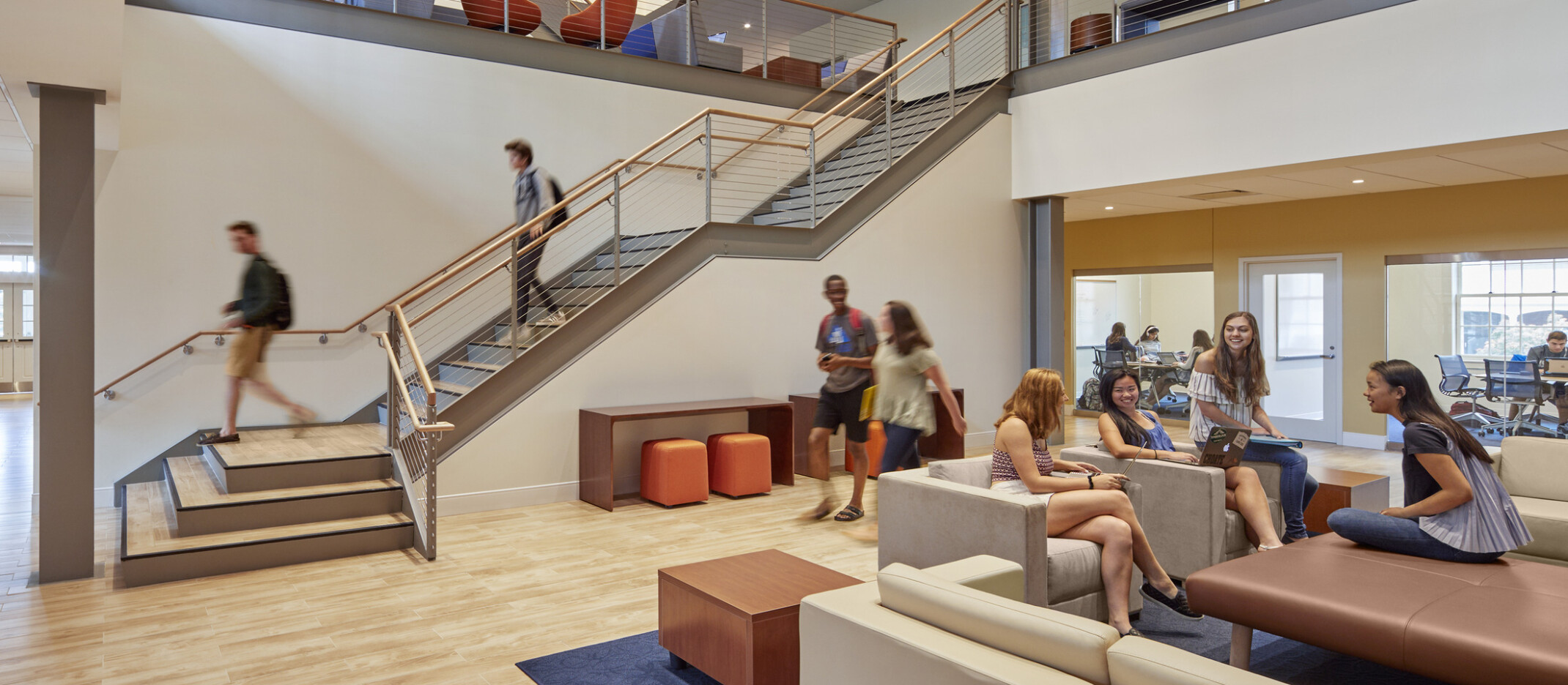 Choate Rosemary Hall school's St. John Hall Student Center triple height atrium with wood panel ceiling accents over chairs