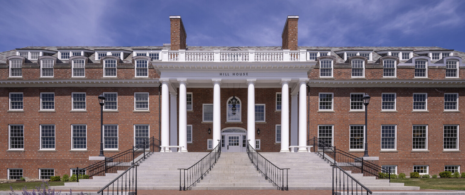 Grey stone front steps with wrought iron rails to column double height entrance of Georgian Revival boarding school dormitory