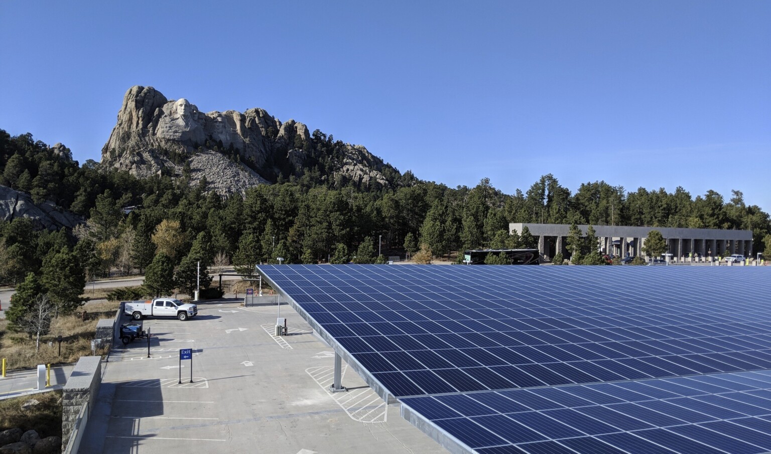 Solar canopy in parking lot in front of Mount Rushmore with trees in between