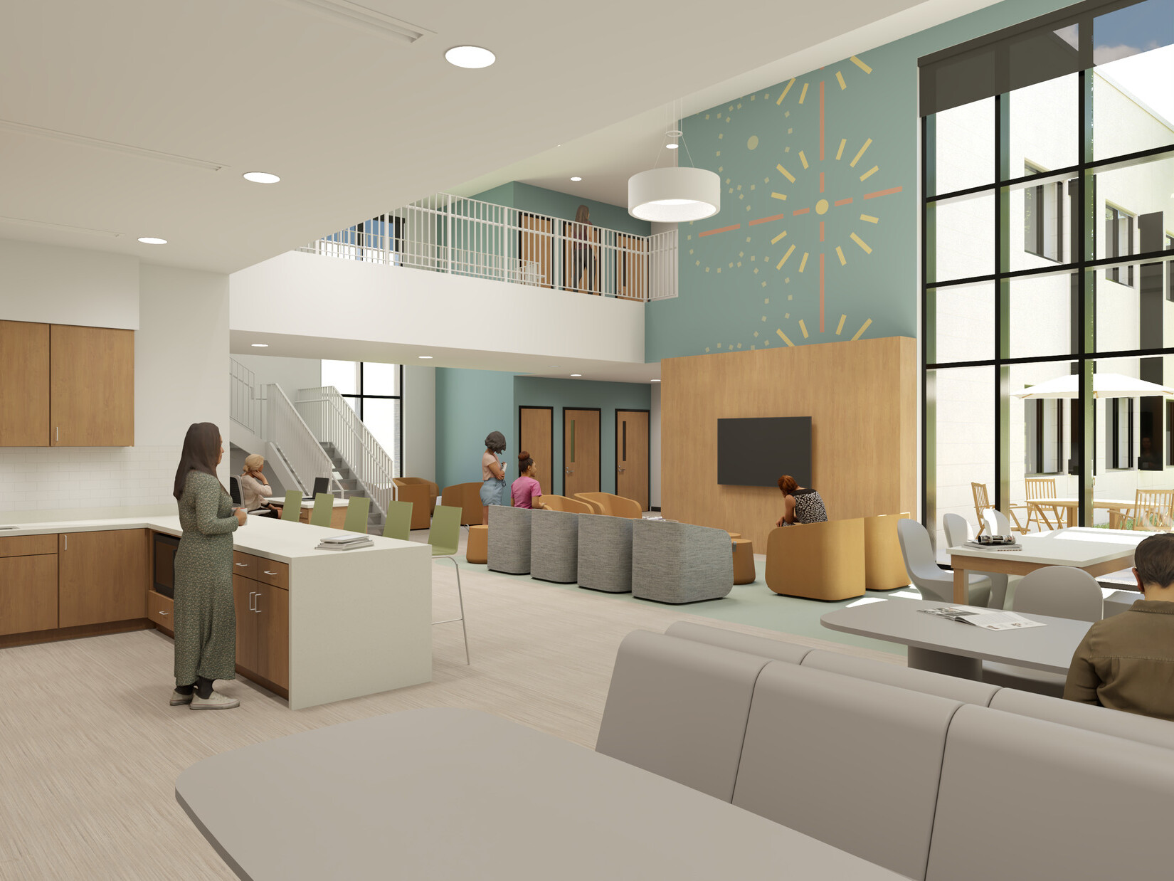 Rendering of a community living space with single-height kitchen on the left opening into a double-height room with library tables and soft seating groups. A window wall on the right looks out onto a secure courtyard with grass and a picnic table.