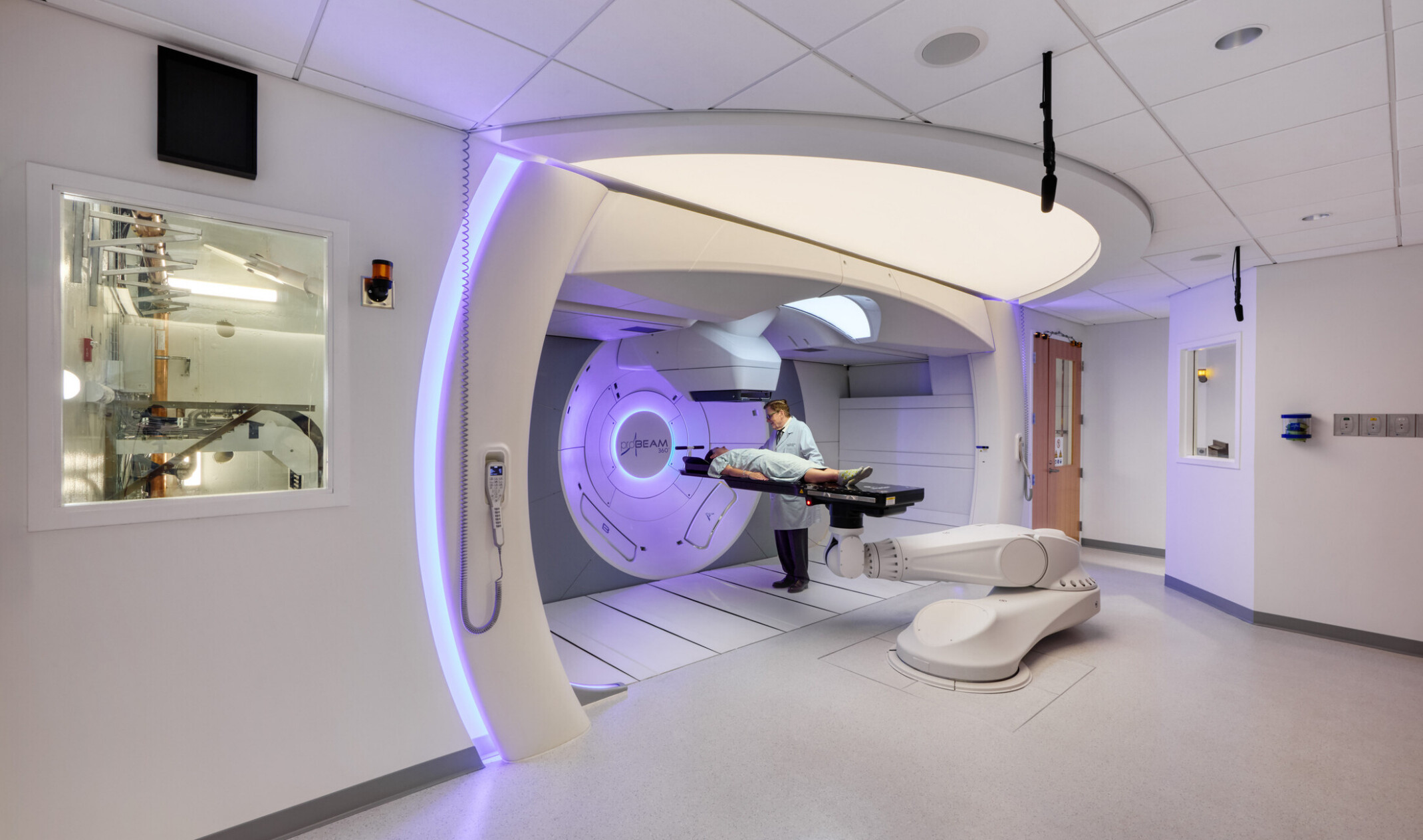 inside a scanning machine at OSF Cancer Institute and Proton Therapy building; blue ambiance surround patient getting treated; small window into technical space of the machine
