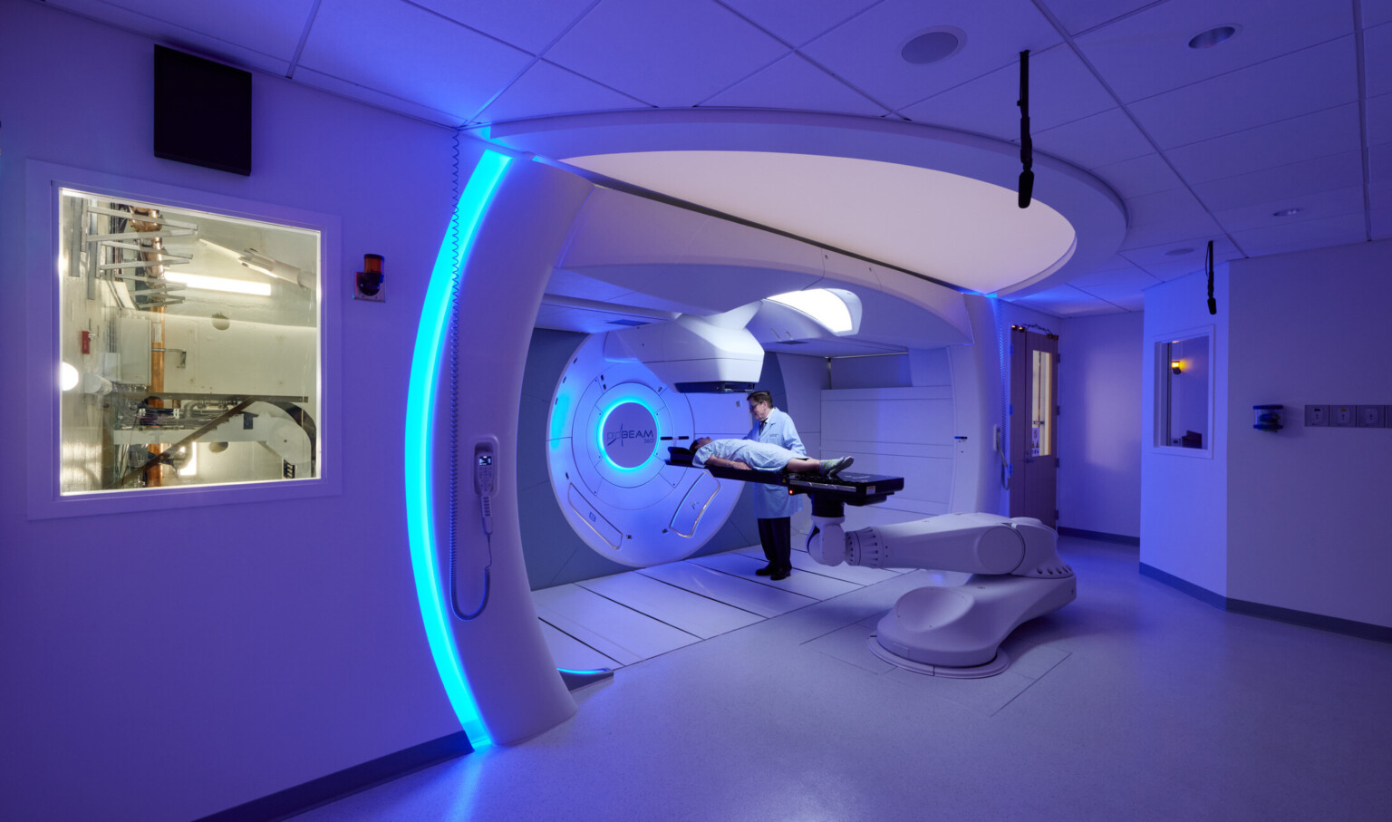 inside a scanning machine at OSF Cancer Institute and Proton Therapy building; blue ambiance surround patient getting treated; small window into technical space of the machine