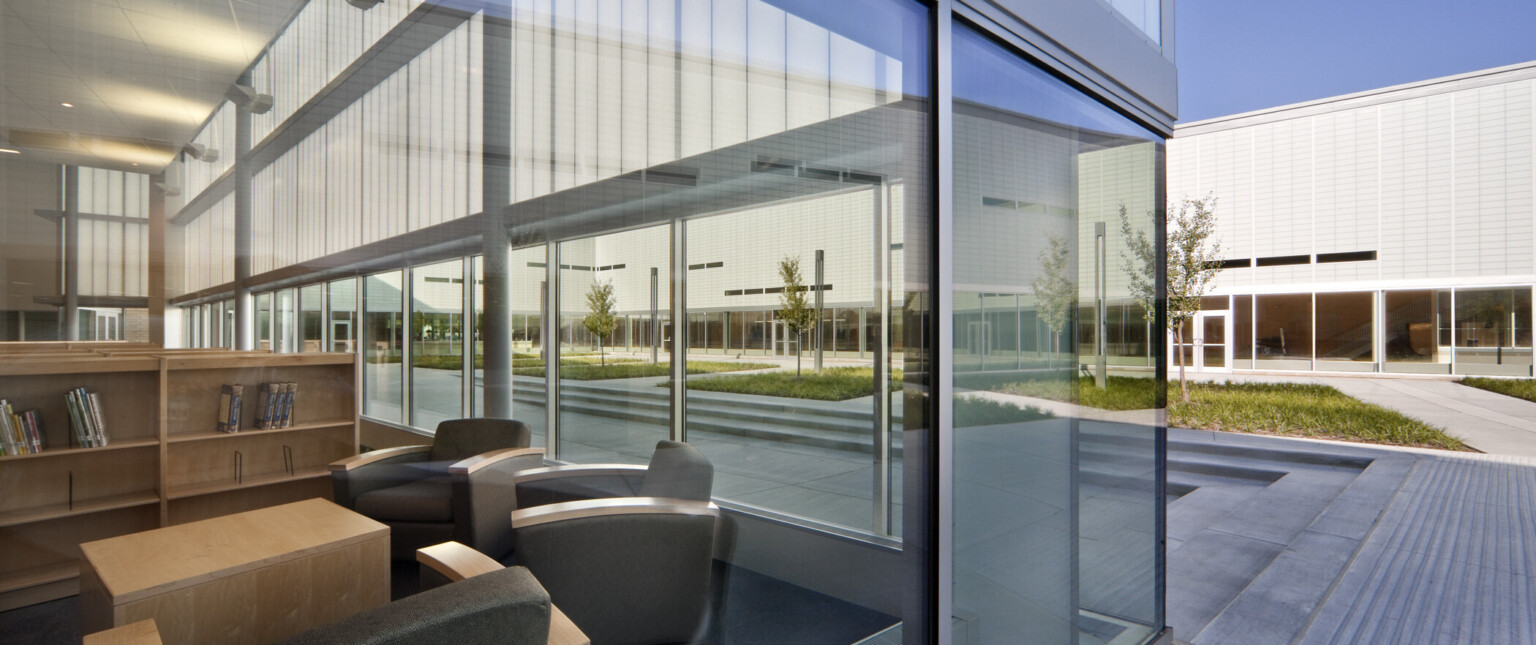 close-up exterior view of learning area, floor-to-ceiling windows, cut-out windows, high-ceilings, overlook outdoor quad, translucent wall panels filter natural light into common spaces