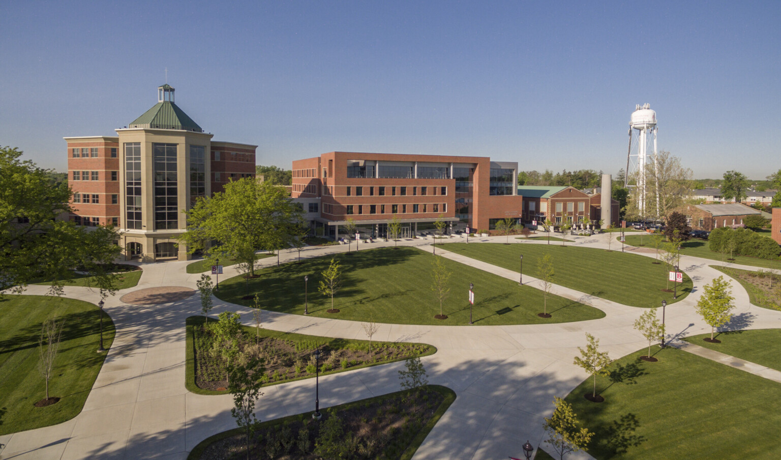 exterior view of Goodwin Hall from across the Quad with grass, trees, and paths to brick wrapped facade building, large windows
