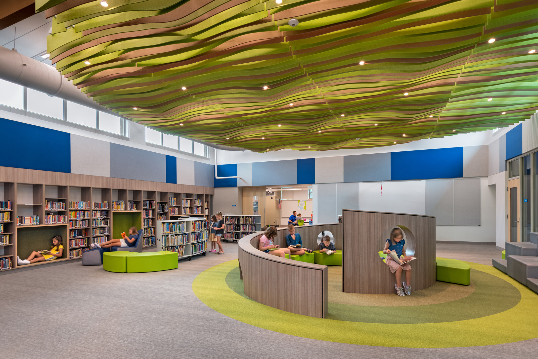 Clara Peterson Elementary School library, mixed comfortbale seating and reading nooks, wavy baffles overhead