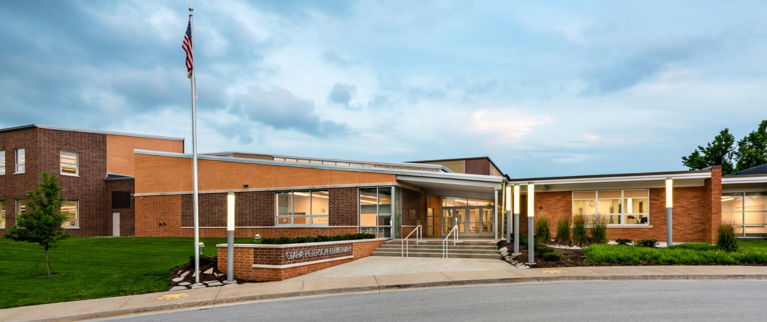 Clara Peterson Elementary School brick facade front entry illuminated in the evening