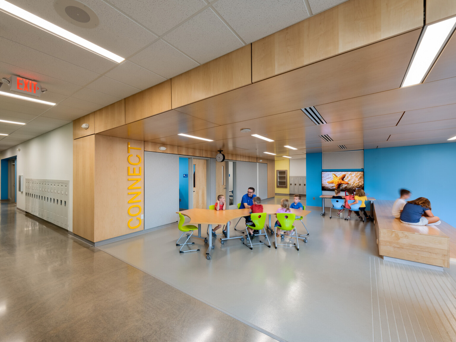 Hallway with recessed common area, wood and blue accents, mixed, flexible seating and screens