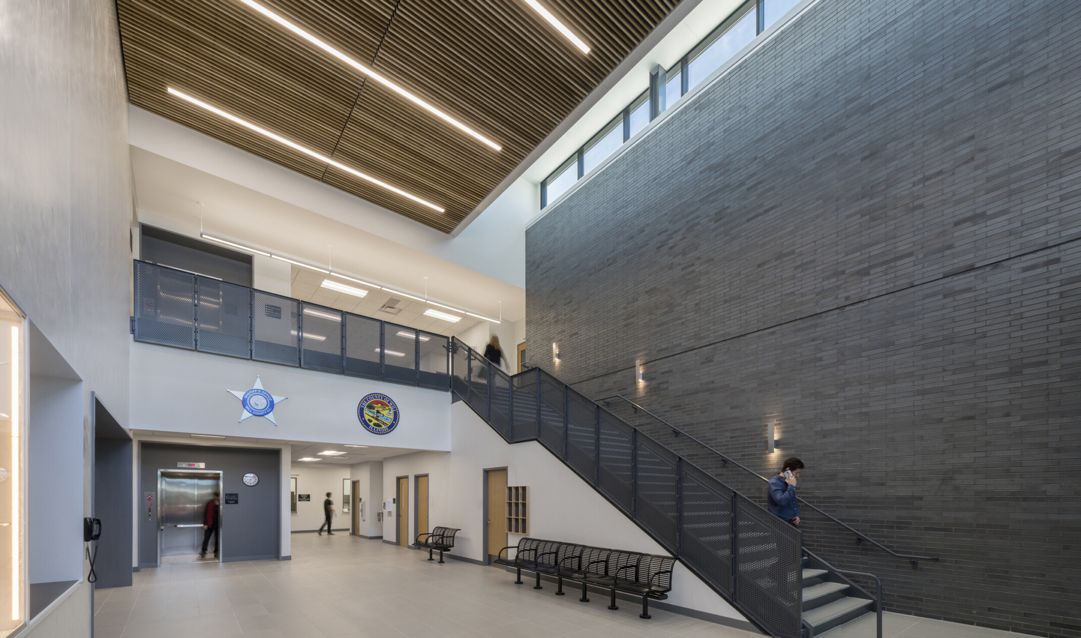 inside Will County Public Safety Center with tall ceilings, grey and white walls and a dark staircase