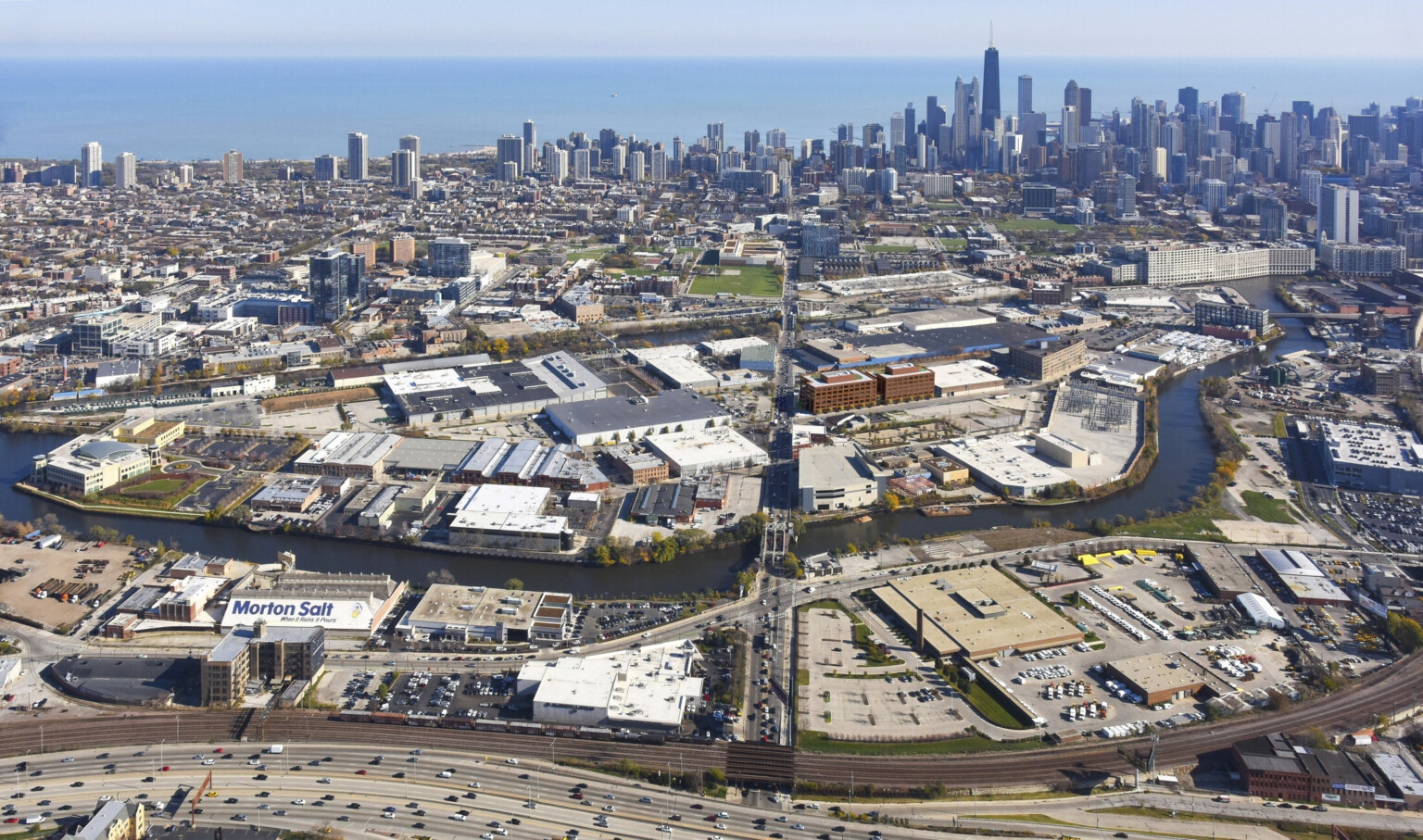 Aerial view of the city of Chicago with cars driving on interstate and buildings in the background. Aerial view of the city of Chicago with cars driving on interstate and buildings in the background.