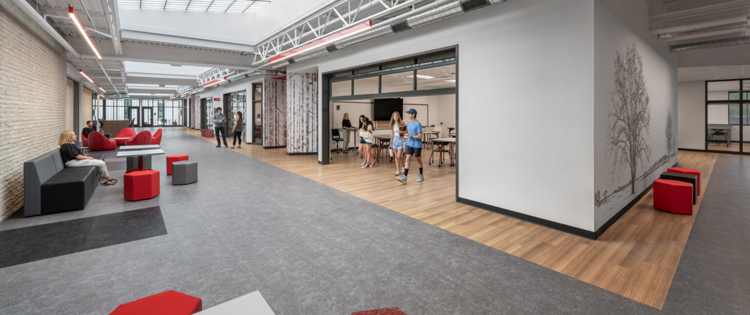 Collaborative school area showing a classroom with a rollup door with students talking.