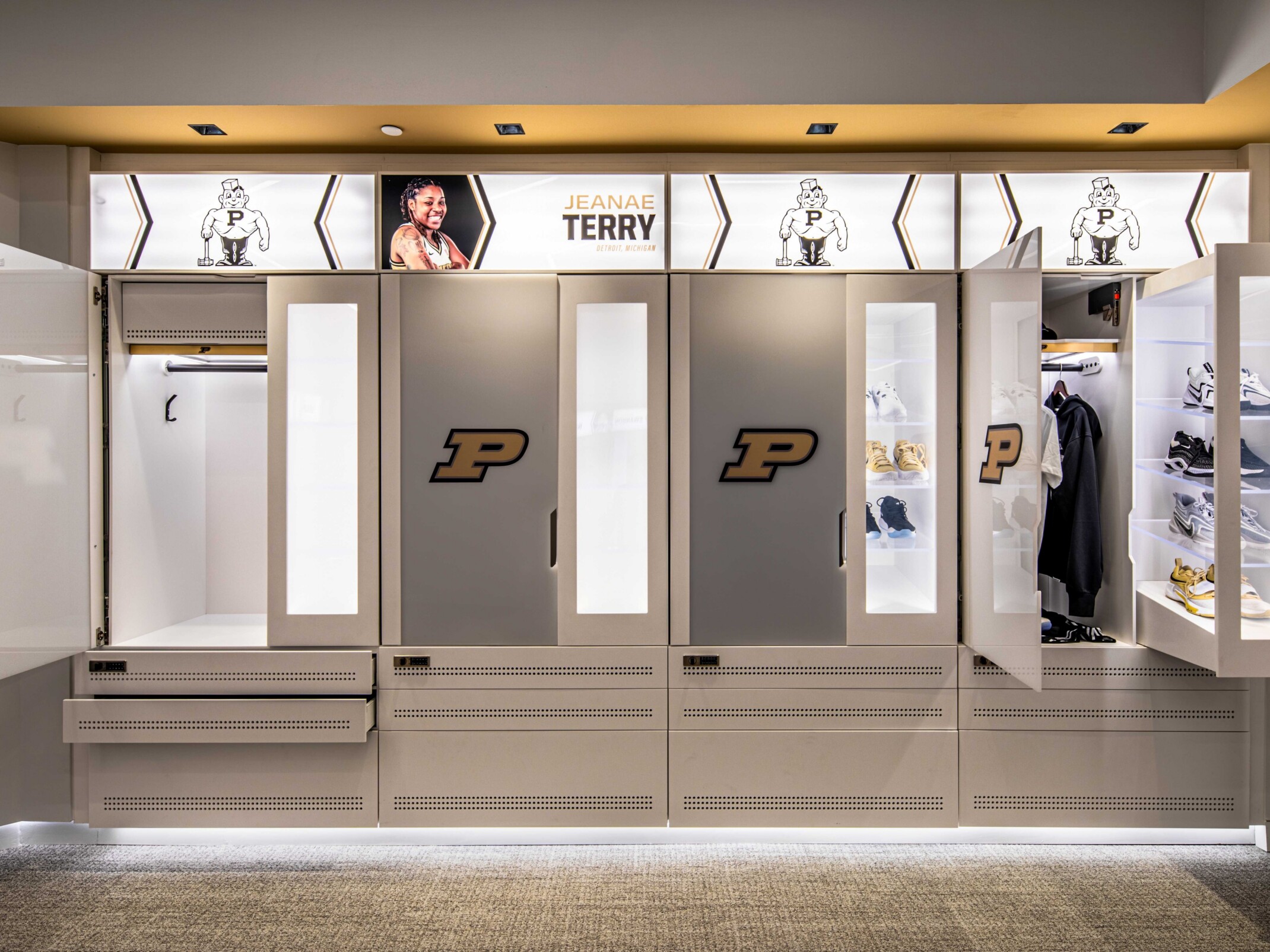 Modern, white and gold lockers for Purdue University; backlit shelves with doors that have the Purdue "P" centered