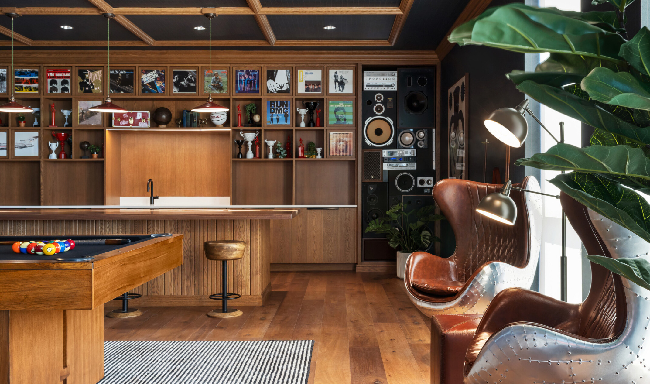 Hub Bloomington off campus student housing; Social lounge with live-edge table, pool table, and eclectic seating.