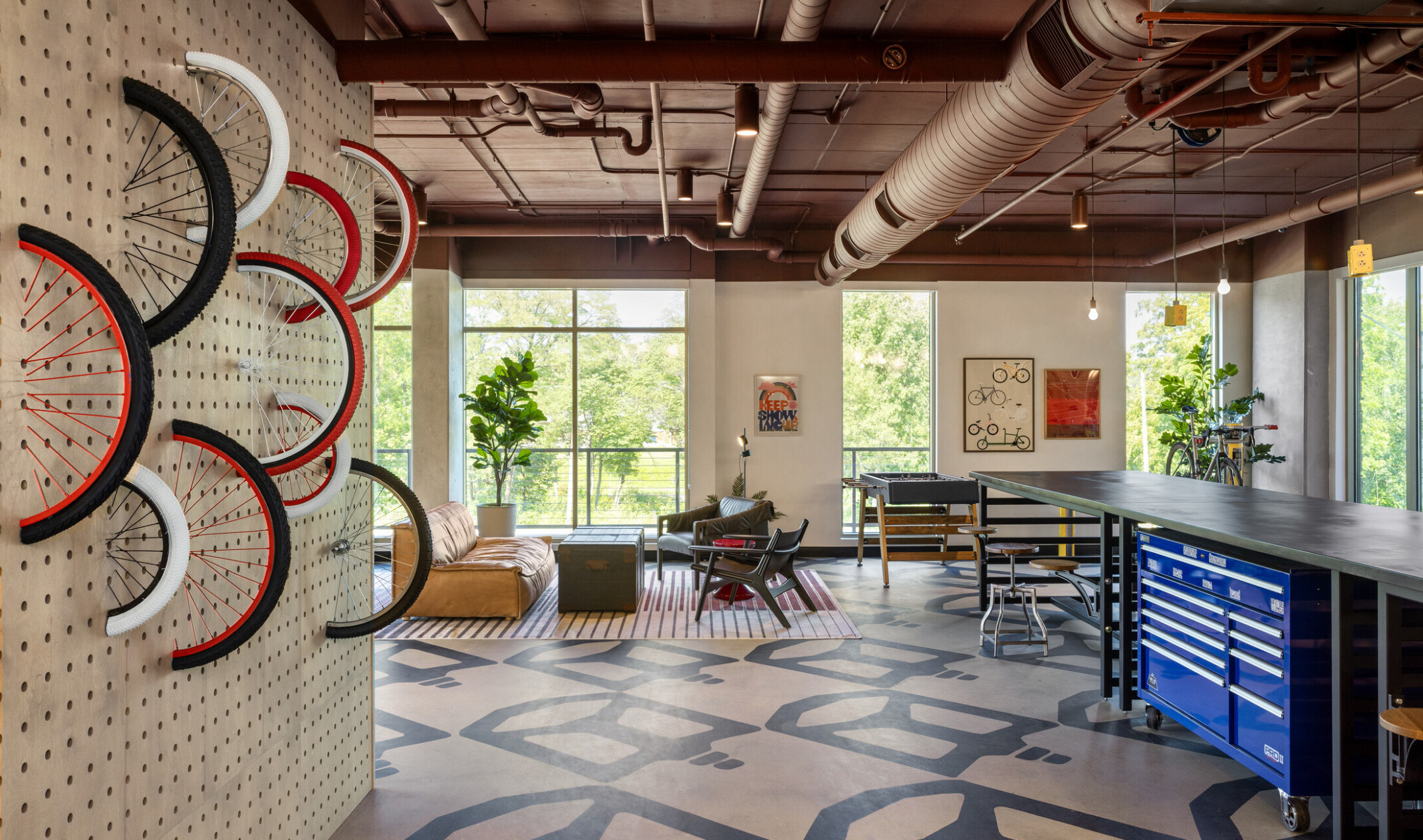 Hub Bloomington off campus student housing; Bike Room with communal table, lounge seating, and bike-themed wall feature.