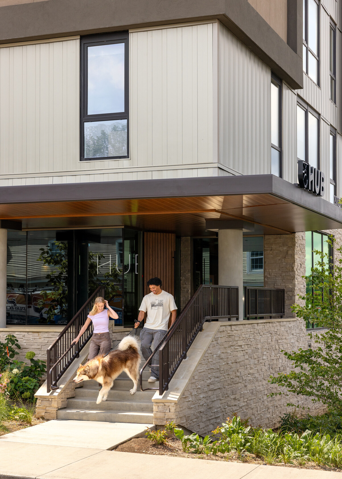 Hub Bloomington off campus student housing; Zoomed view of the main entrance as students head out with their dog.