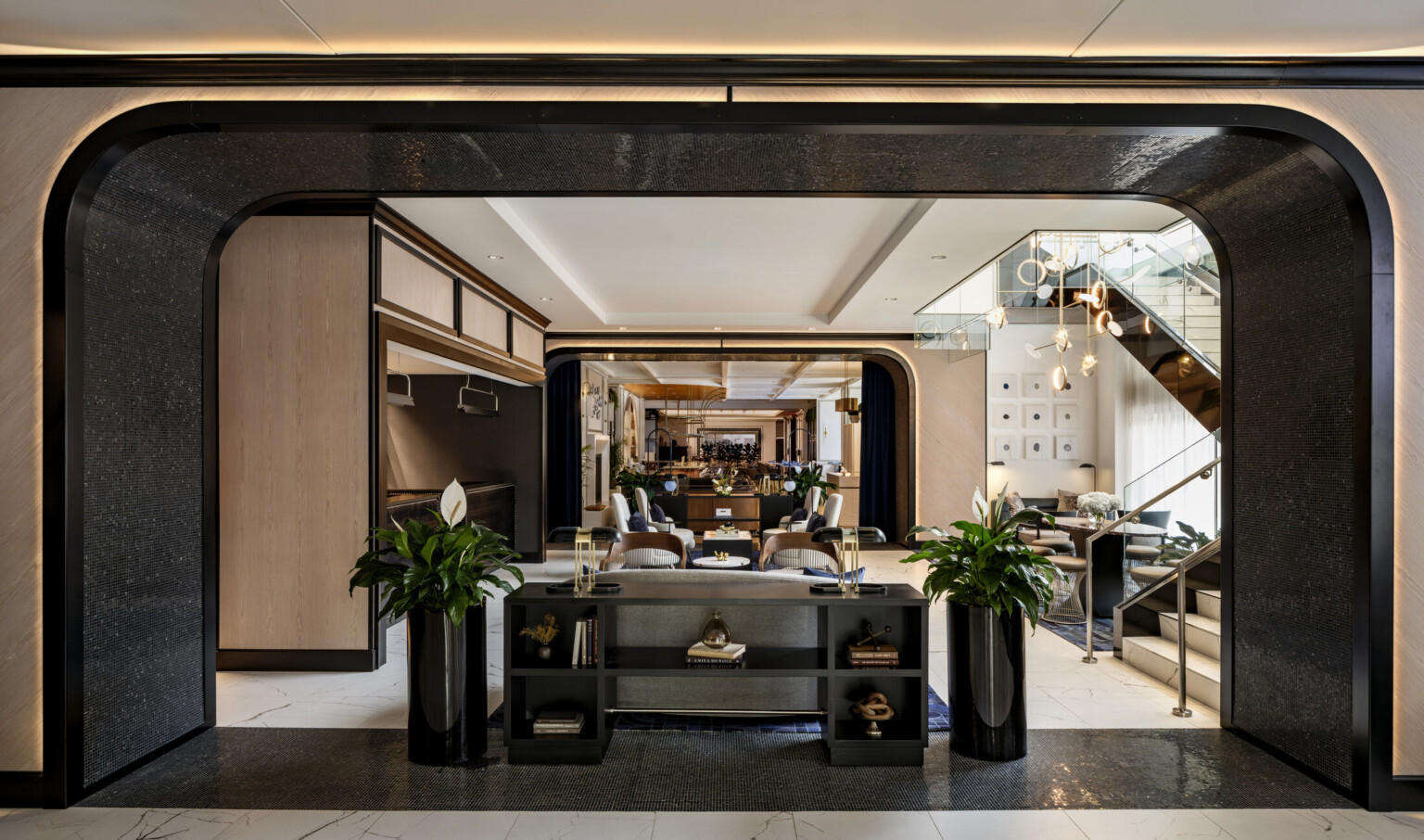 The Vanguard Hotel, Autograph Collection lobby; archway with seating and tables for guests; elegant dark and light wood for a modern but historical feel