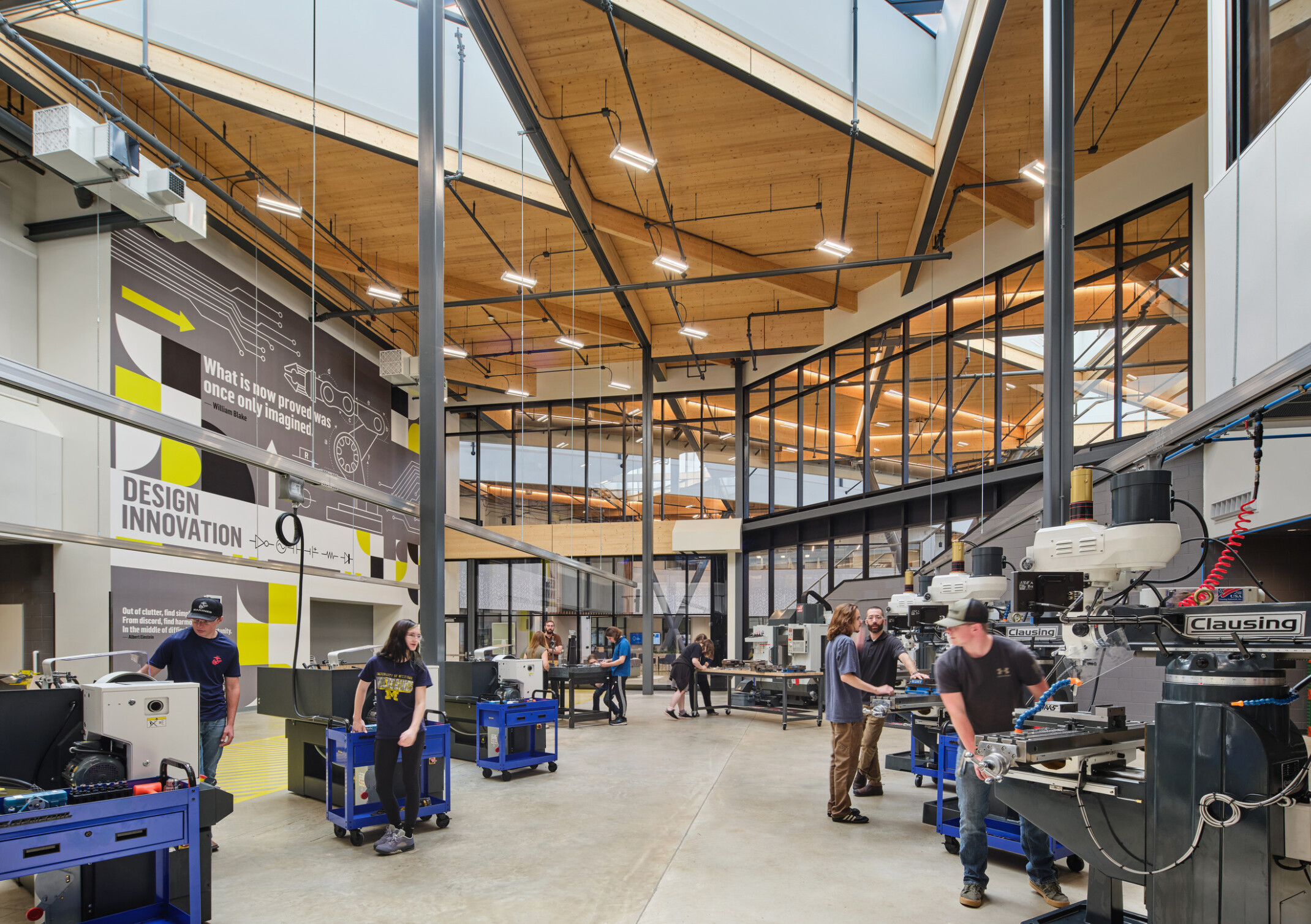 Technical classroom within Kalamazoo RESA career technical education building featuring exposed wood structure, natural materials, and biophilic design elements; students working at stations in a large double height space