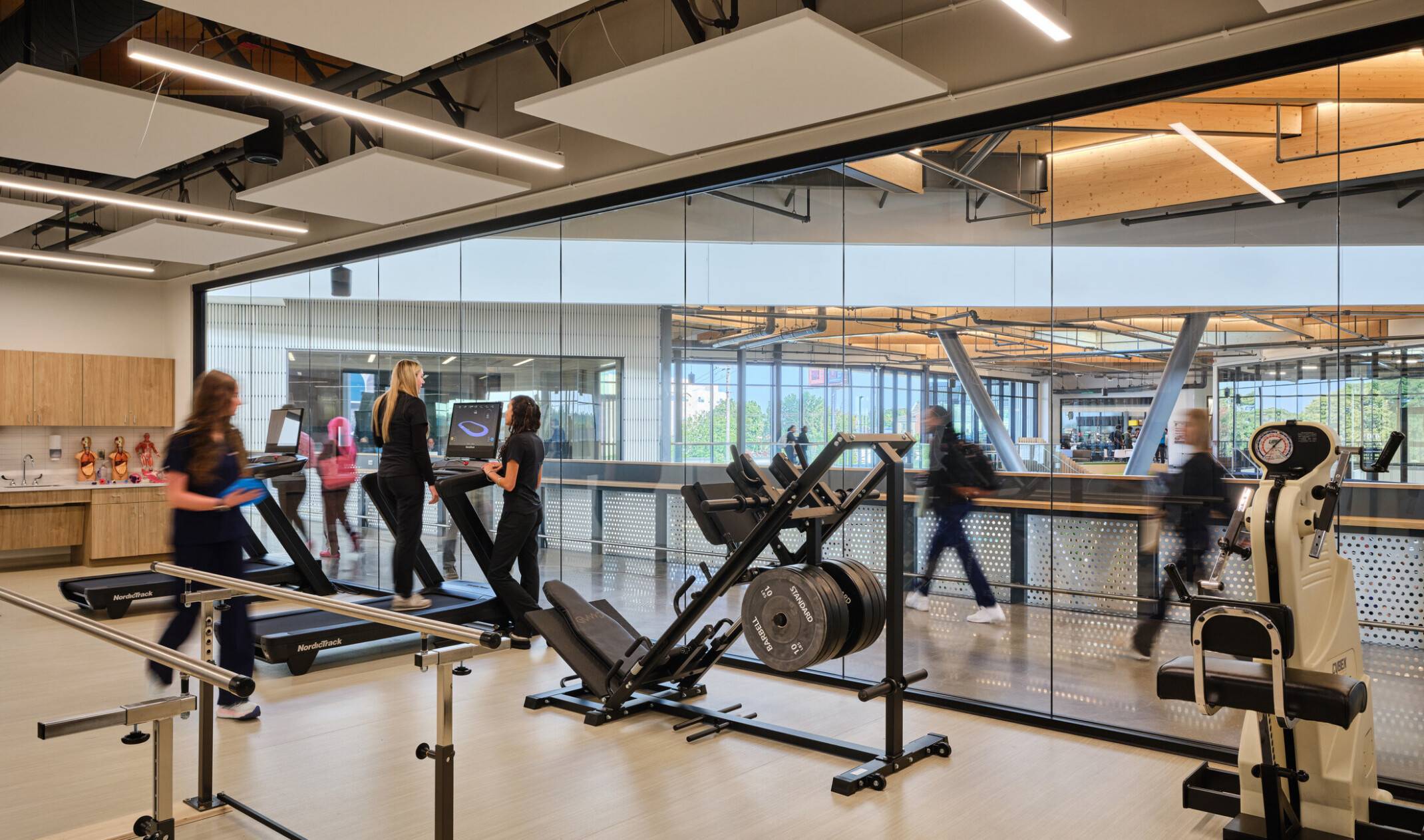 Technical classroom within Kalamazoo RESA career technical education building featuring exposed wood structure, natural materials, and biophilic design elements; students working at stations