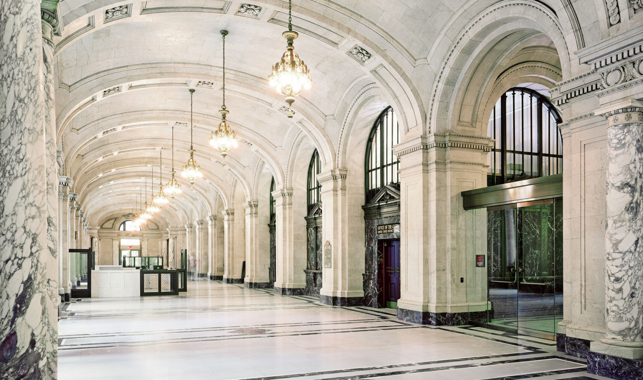 Looking down the hallway in an historic federal courthouse building; restored building; ornate tile and arched columns