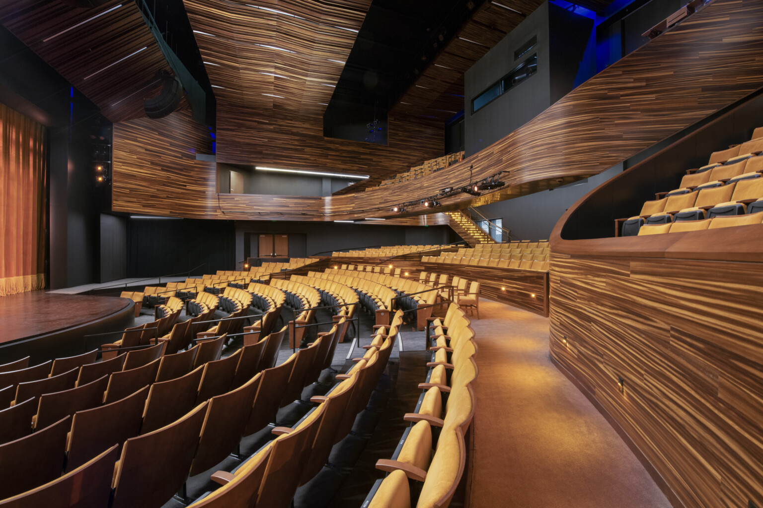 theater with wooden finishes and yellow seating, stairs on the right to balcony at Point Park University Pittsburgh Playhouse