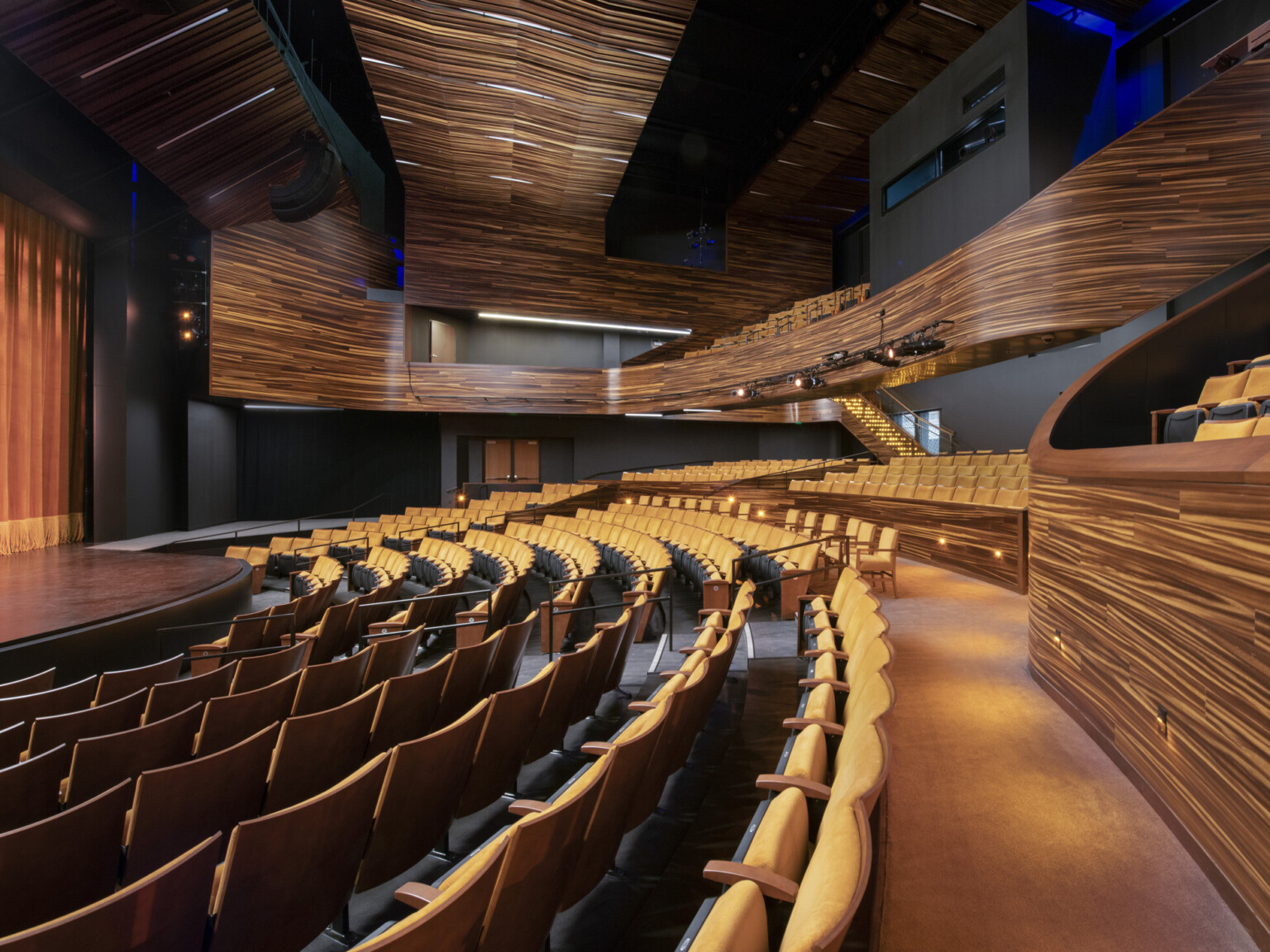 theater with wooden finishes and yellow seating, stairs on the right to balcony at Point Park University Pittsburgh Playhouse