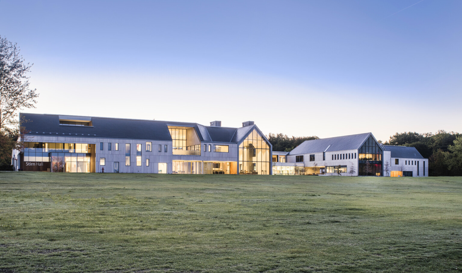Exterior view from lawn of building labeled Stirn Hall. Sections of recessed window in a grey 3 story building
