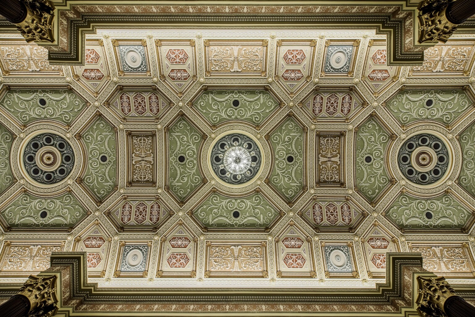 intricately designed ceiling with crown molding; green and light red coloring throughout