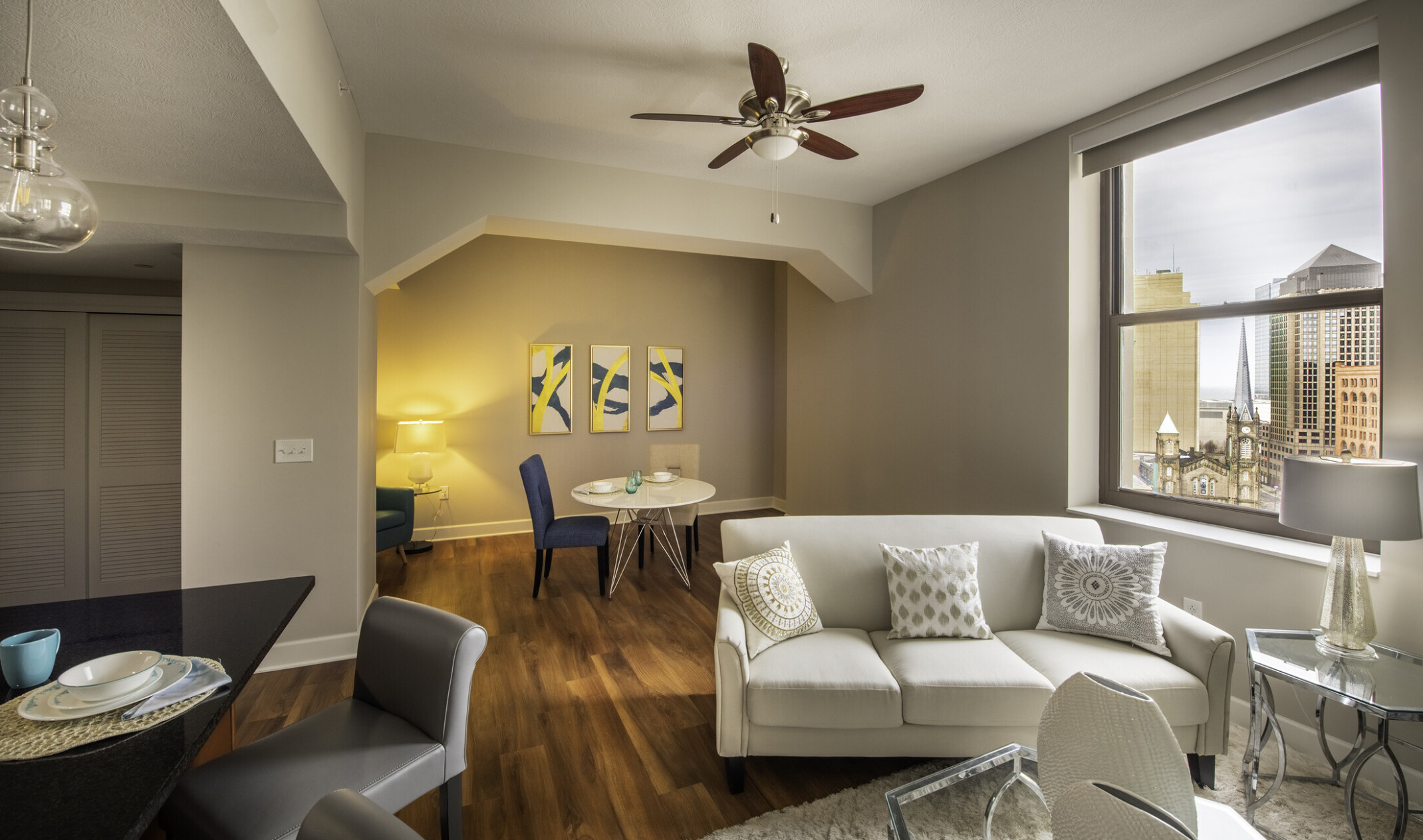 interior photo of a modern apartment living space; couch facing forward; kitchen table behind the couch