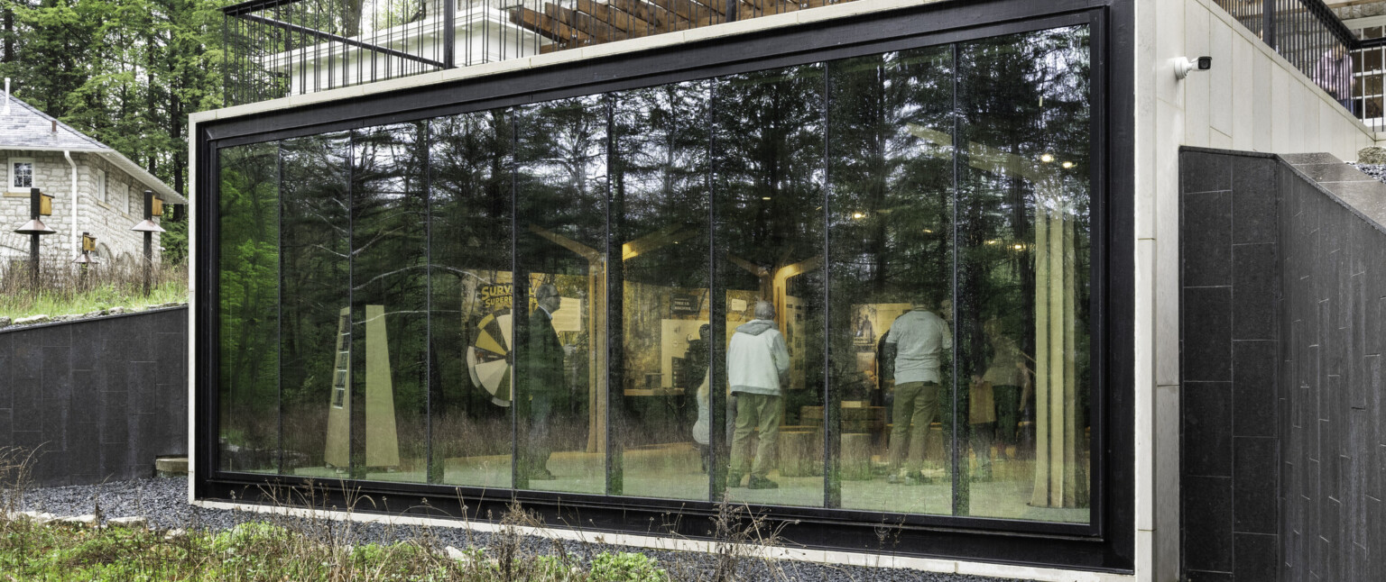 Looking inside a building through a wall of windows onlooking a group of people Looking inside a building through a wall of windows onlooking a group of people
